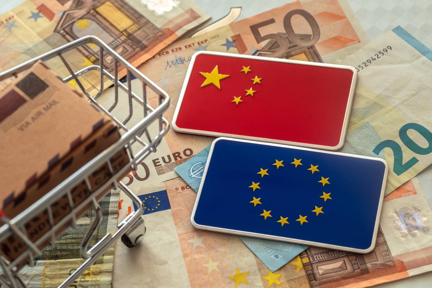 Banderas de China y Europa junto con dinero y un carrito de compras