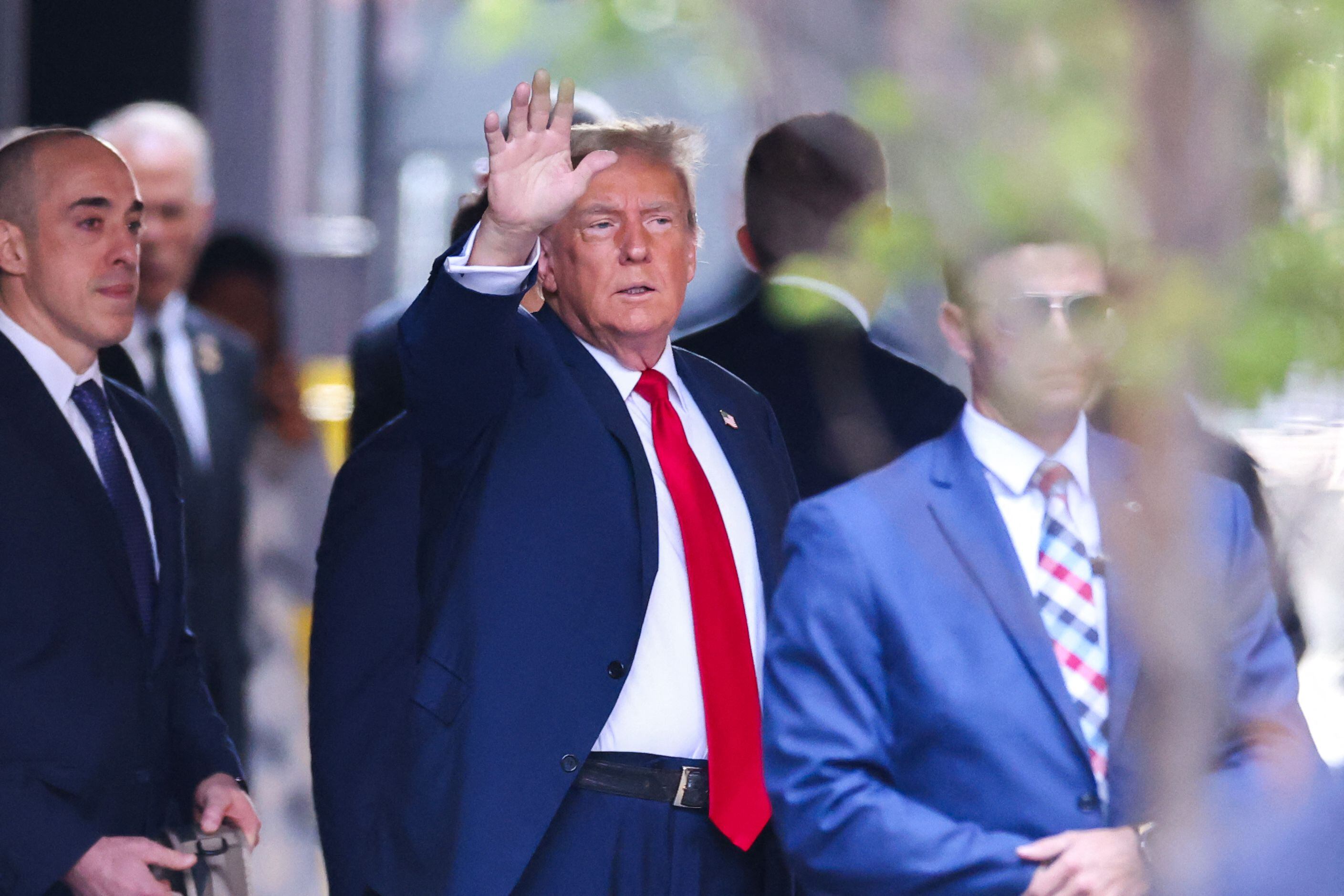 El expresidente estadounidense Donald Trump saluda mientras sale de la Torre Trump hacia el Tribunal Penal de Manhattan