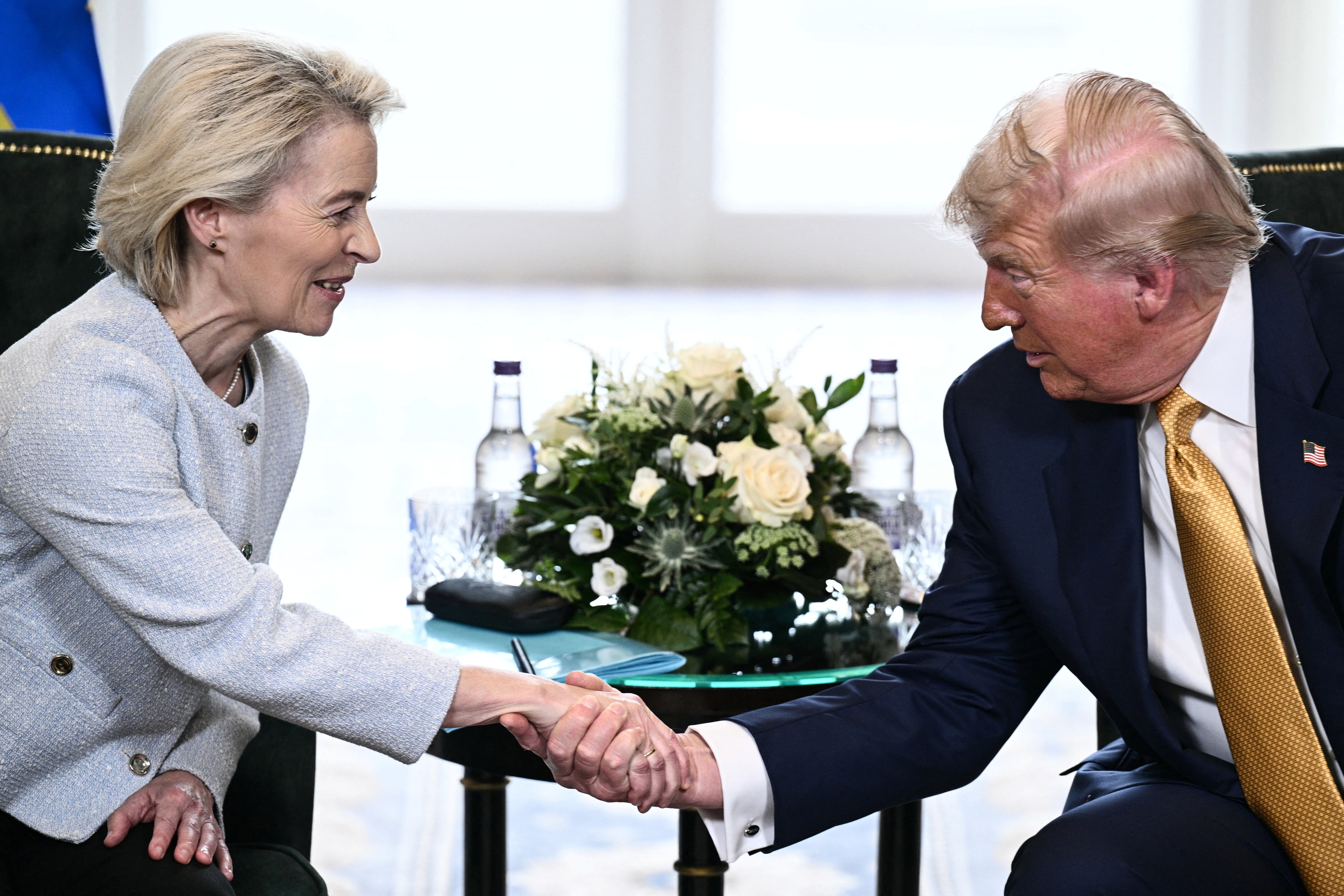US President Donald Trump (R) shakes hands with European Commission President Ursula von der Leyen (L) during a meeting, in Turnberry south west Scotland, on July 27, 2025, on the third day of his visit to the country, since his second tenure as President began. Trump has said he sees a 50-50 chance of reaching a deal with the European Union, having vowed to hit dozens of countries with punitive tariffs unless they hammer out a pact with Washington by August 1, 2025. (Photo by Brendan SMIALOWSKI / AFP)
