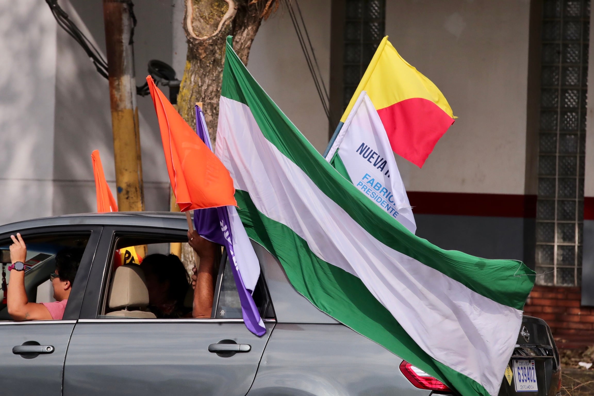 Un vehículo con banderas de distintos partidos políticos.