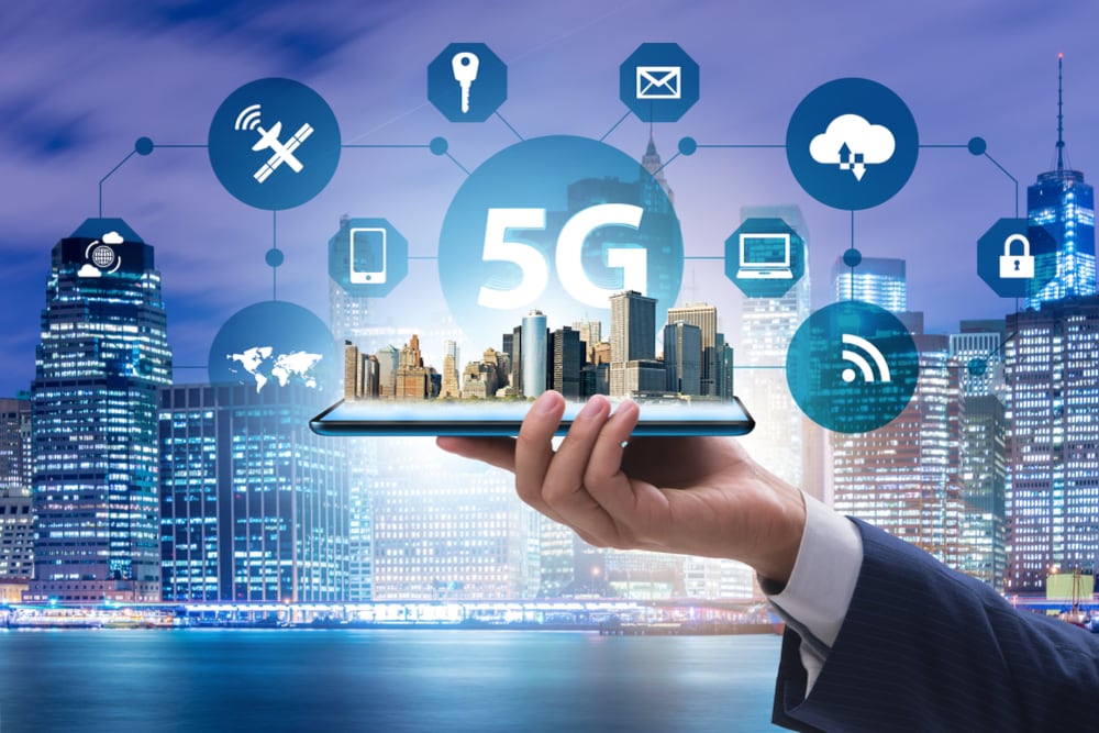 Mano sostiene un plano a escala de una ciudad conectada con íconos de tecnología.