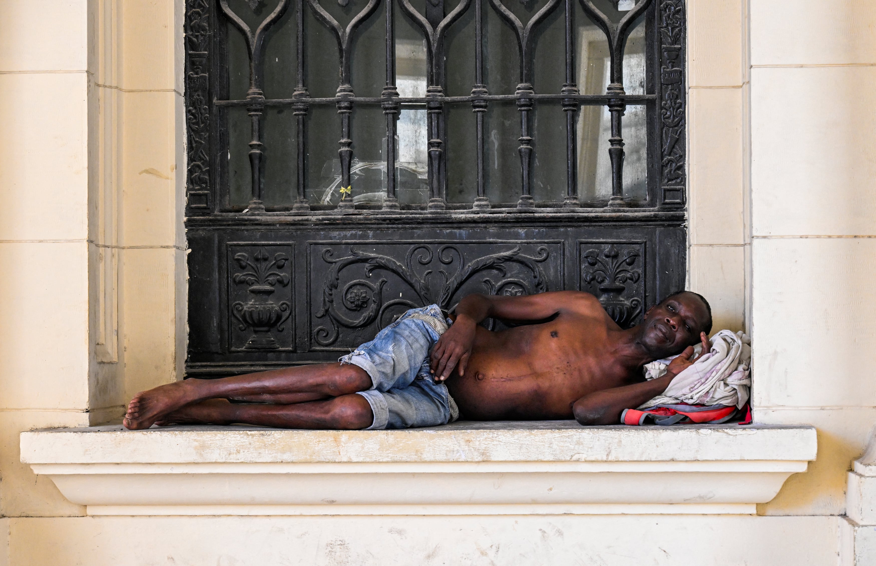 Una persona sin hogar yace en una calle de La Habana el 21 de julio de 2025. Los niveles de pobreza han aumentado drásticamente mientras el país caribeño enfrenta su peor crisis económica en tres décadas, marcada por la escasez de alimentos, medicamentos y combustible, y apagones diarios. La ministra cubana de Trabajo y Seguridad Social, Marta Elena Feitó, renunció el 21 de julio de 2025 tras afirmar que no hay "mendigos" en la isla, sino personas "disfrazadas de mendigos". (Foto de Yamil LAGE / AFP)
