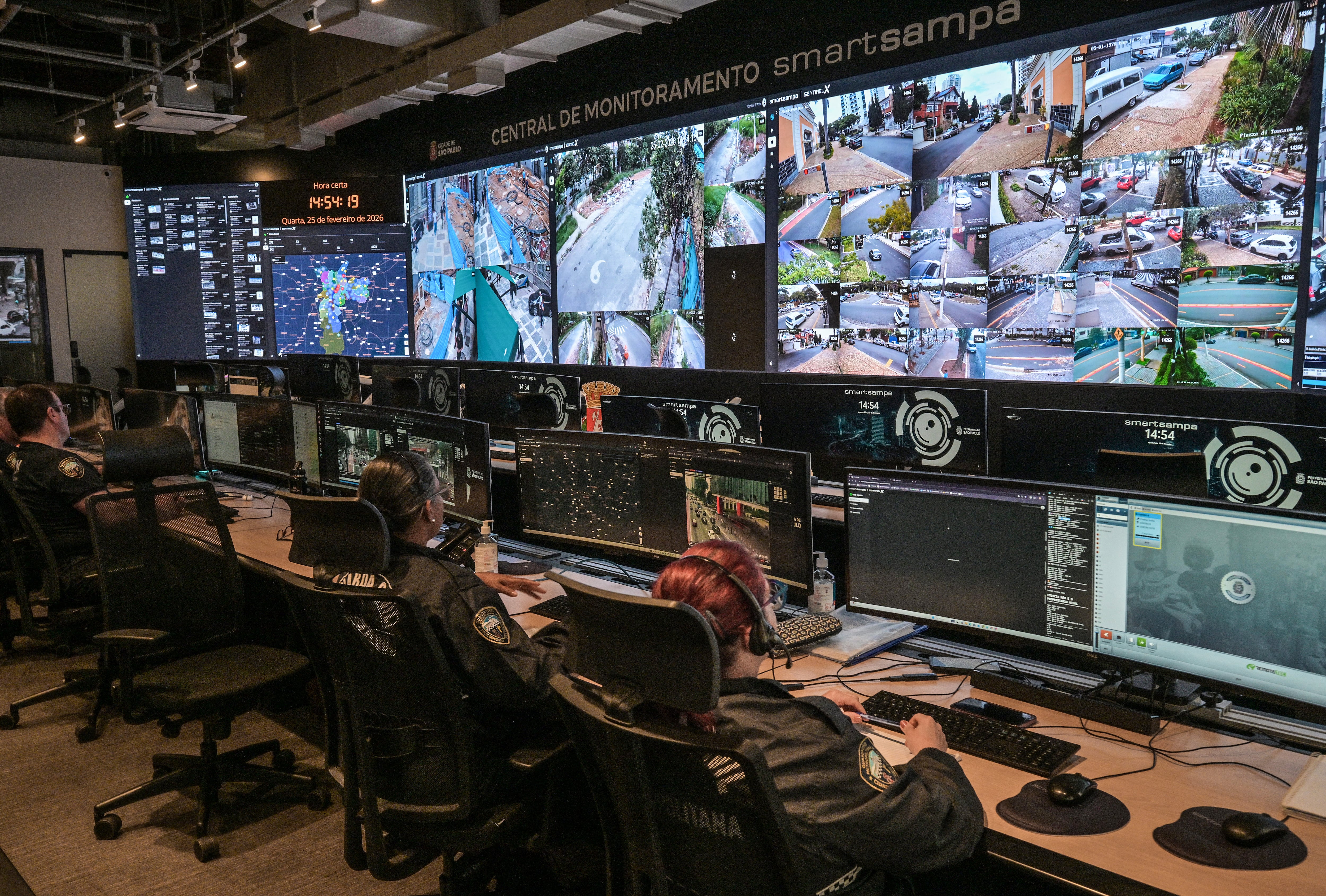 Empleados trabajan en el centro de monitoreo de Smart Sampa en São Paulo, Brasil, el 25 de febrero de 2026. En el corazón de São Paulo, un "prisonómetro" lleva un registro en tiempo real de las personas encarceladas gracias al sistema de reconocimiento facial con IA más grande de Latinoamérica, pero sus éxitos se han visto empañados por arrestos erróneos. El contador digital se encuentra fuera del centro de monitoreo de Smart Sampa, donde decenas de policías observan las imágenes que llegan de 40.000 cámaras en la megalópolis brasileña.