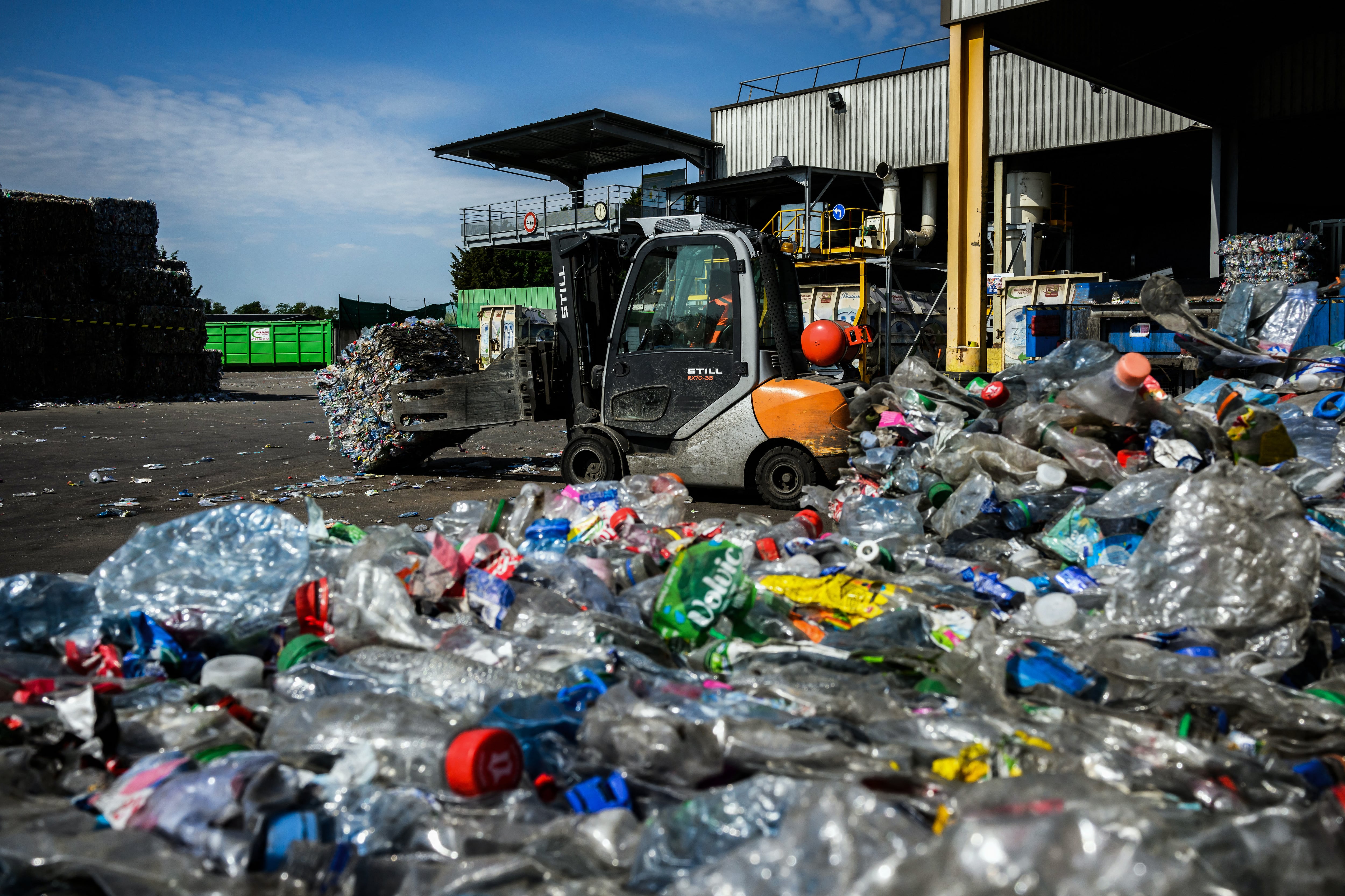 Un montacargas mueve paquetes de botellas de plástico PET antes de reciclarlas.