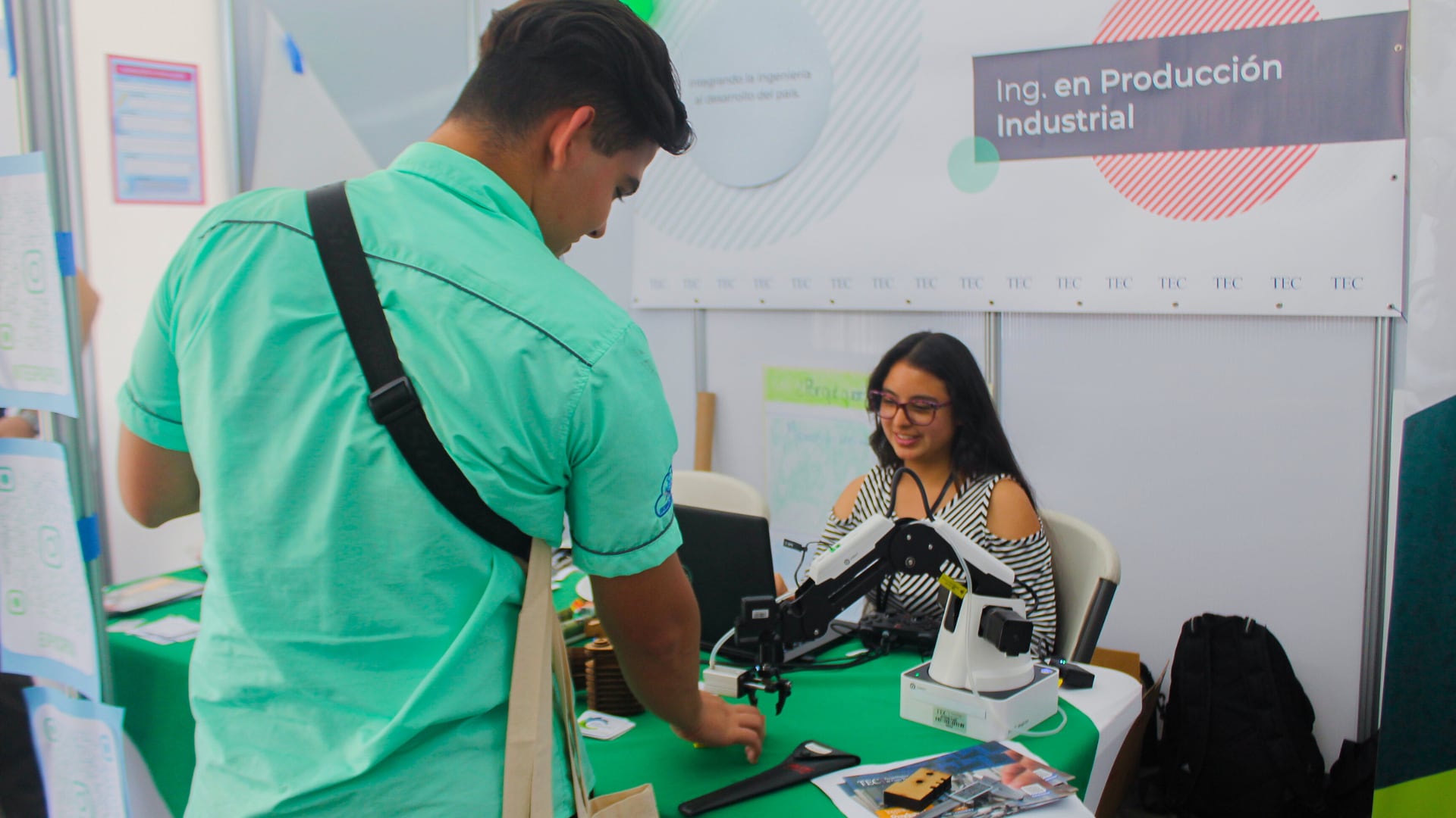 Un estudiante interactúa con una representante de la carrera de Ingeniería en Producción Industrial en la Feria Vocacional del TEC, donde se brindó información sobre programas académicos y servicios estudiantiles.