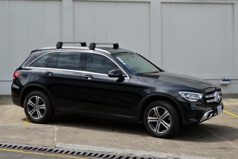 Imagen de un Mercedes Benz GLC 200 negro del año 2020, con cuatro puertas, transmisión automática y motor a gasolina, estacionado en vista lateral.