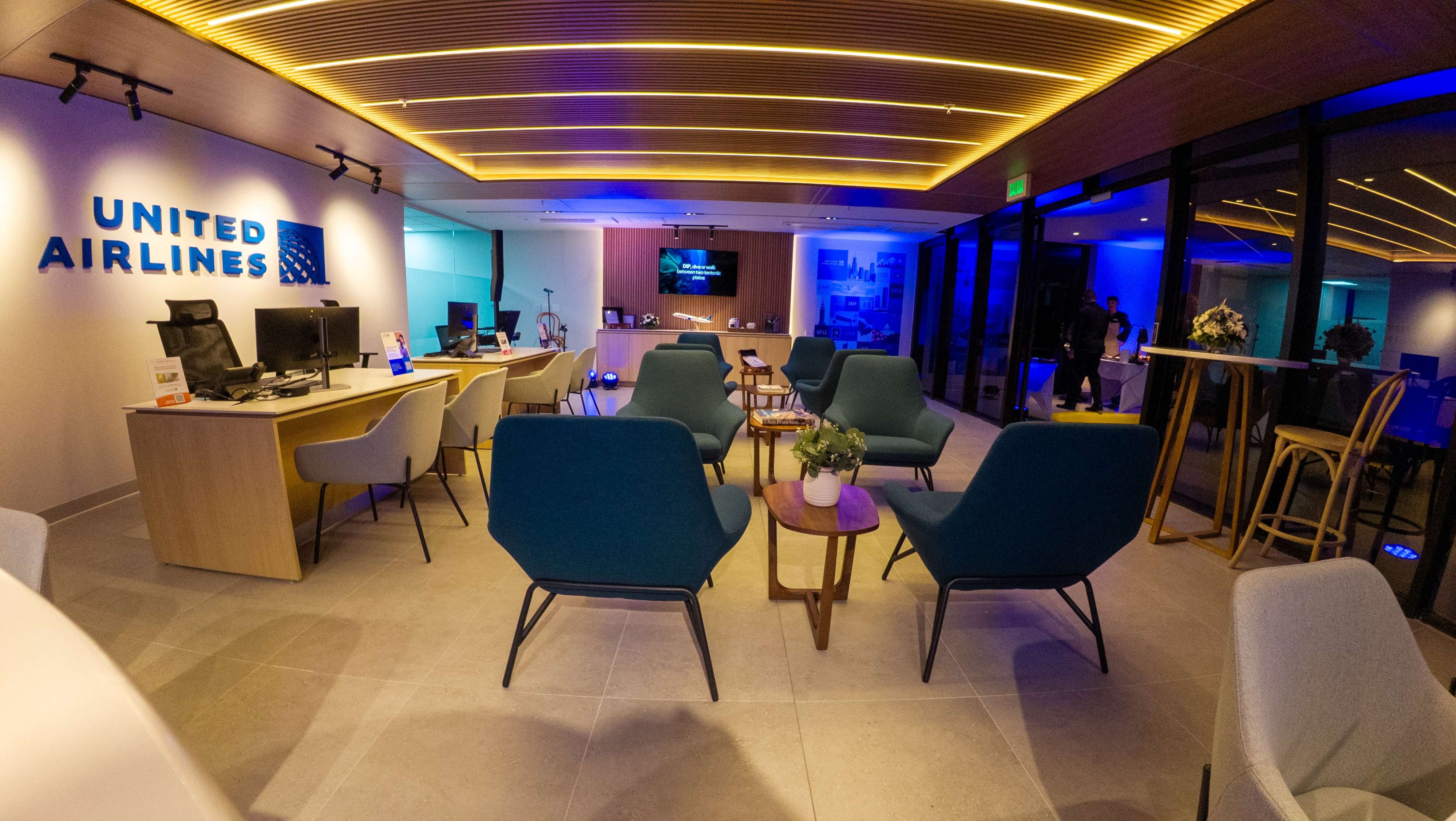 Área de servicio al cliente de United Airlines en San José, mostrando cuatro mostradores de atención modernos y sillones de espera de estilo lounge.