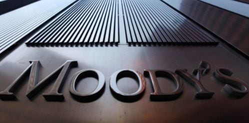 Logo de Moody’s grabado en metal, destacado sobre una fachada corporativa.