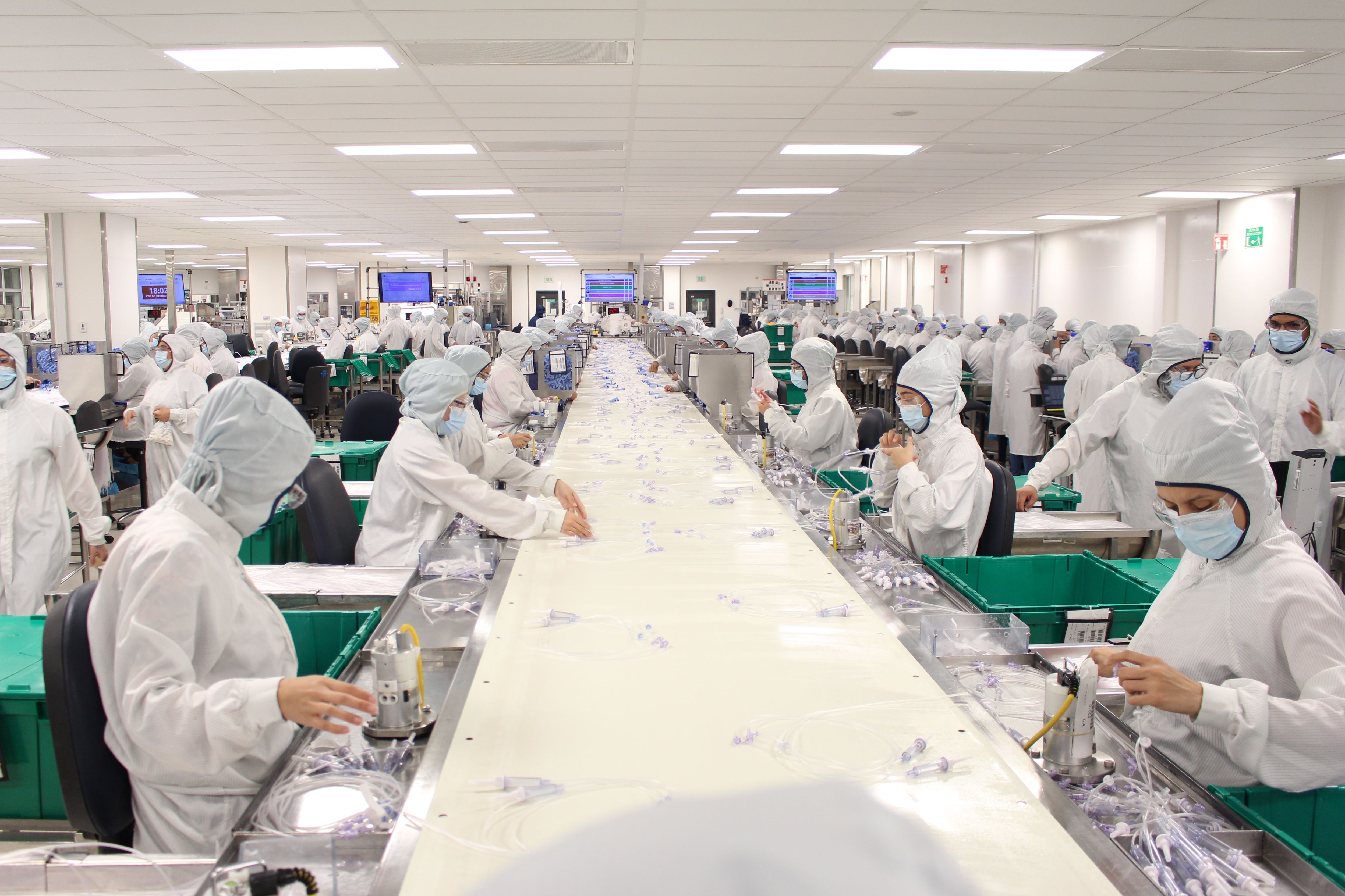 Vista de una línea de producción de dispositivos médicos en Costa Rica, con personal en trajes especializados ensamblando productos. Este sector lideró las exportaciones nacionales en 2024.