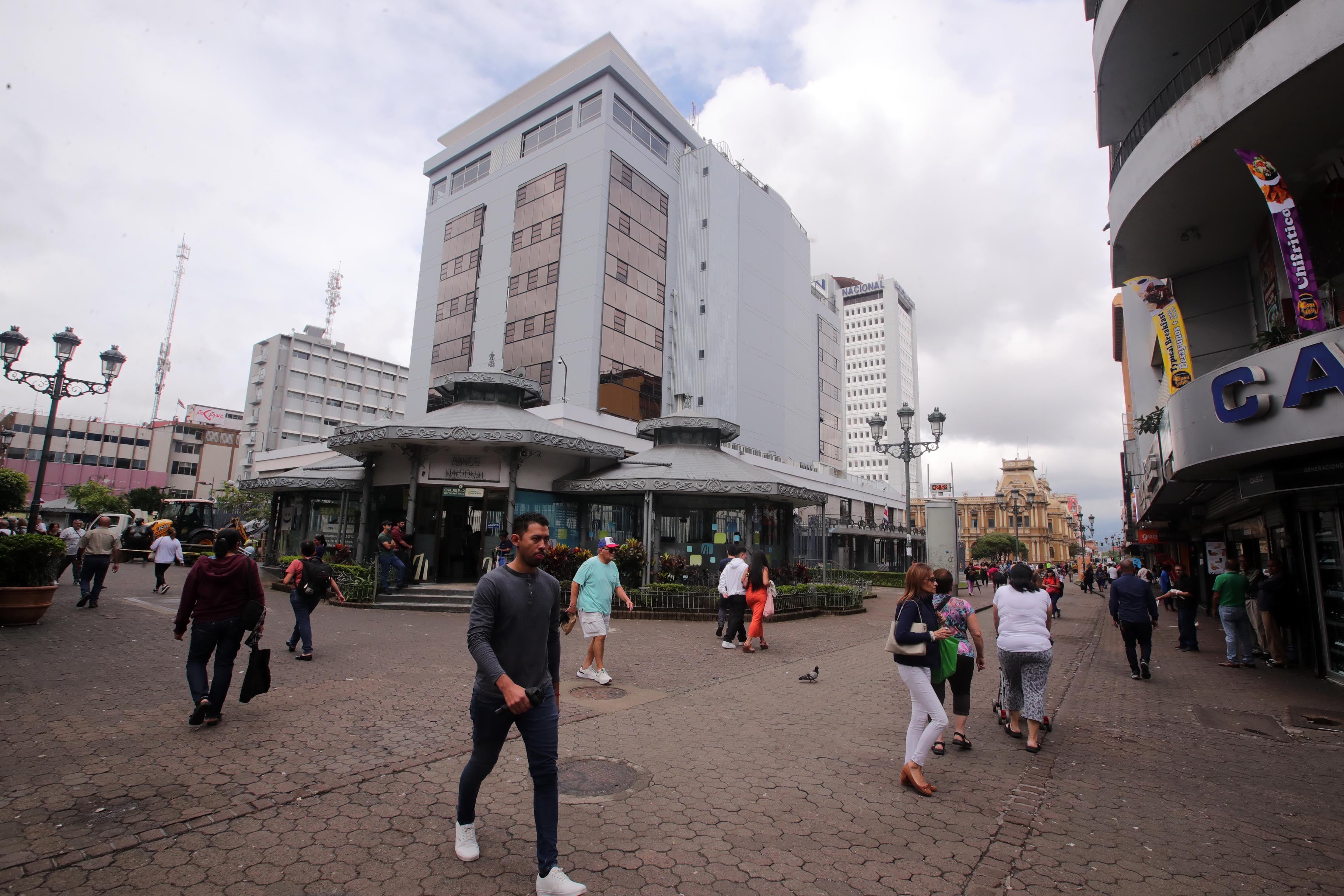 Edificio del Banco Central en la Avenida Central de San José. Personas caminan al lado del edificio.