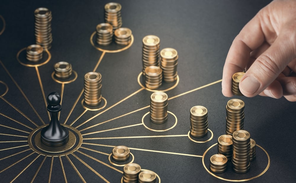 Monedas distribuidad desde un centro marcado por una pieza de ajedrez.