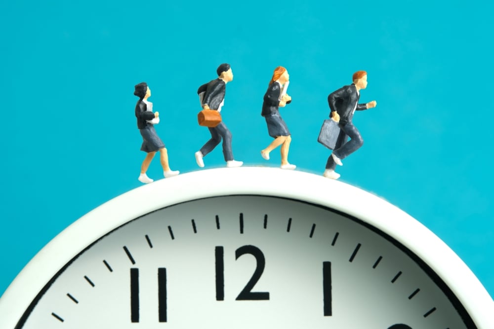 Un grupo de ejecutivos corriendo sobre un reloj.