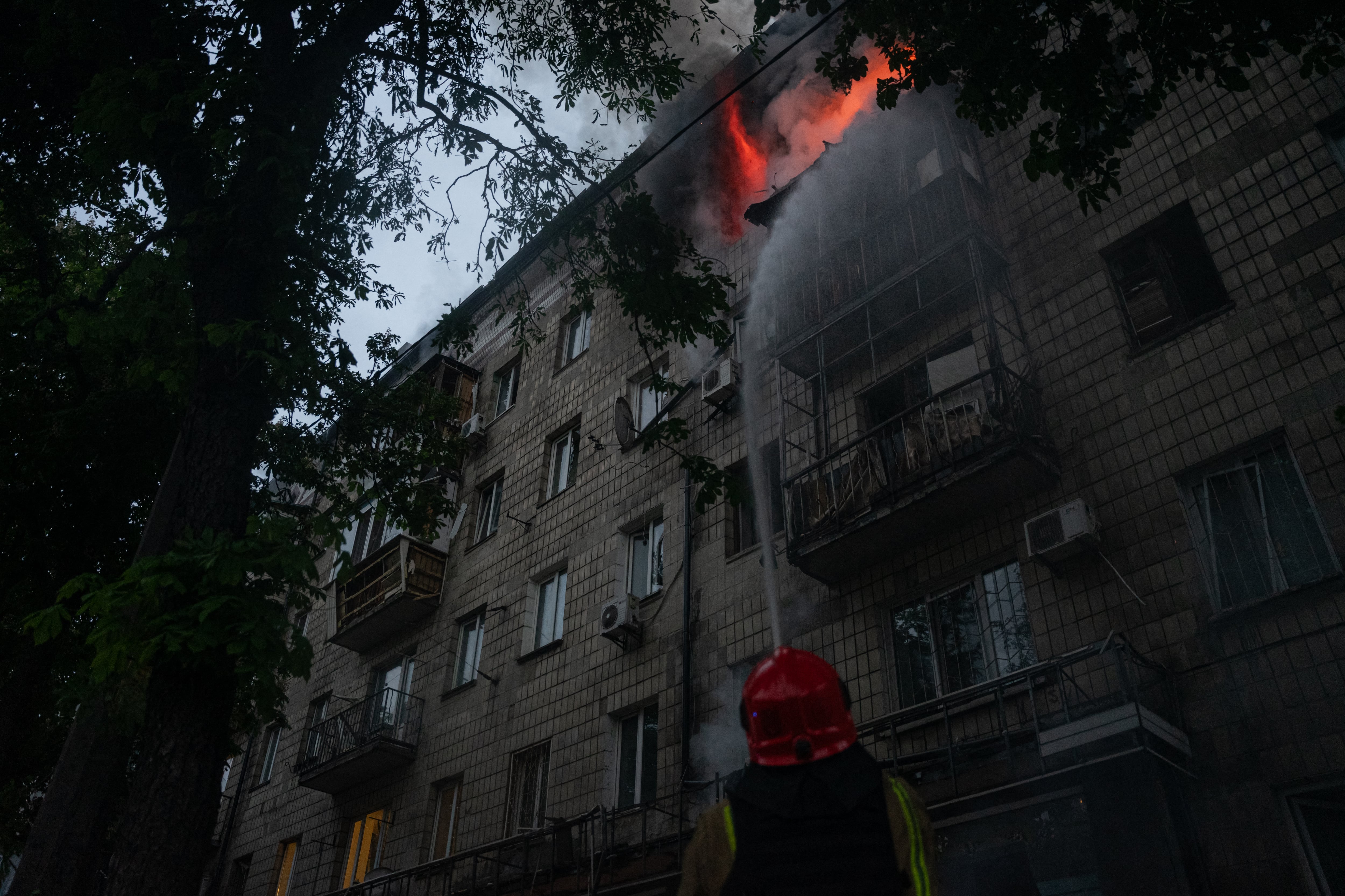 Imagen difundida por el Servicio Estatal de Emergencias de Ucrania el 7 de mayo de rescatistas apagando un incendio en un edificio residencial tras un ataque con un dron ruso en Kiev, durante la invasión rusa de Ucrania. Fotografía: