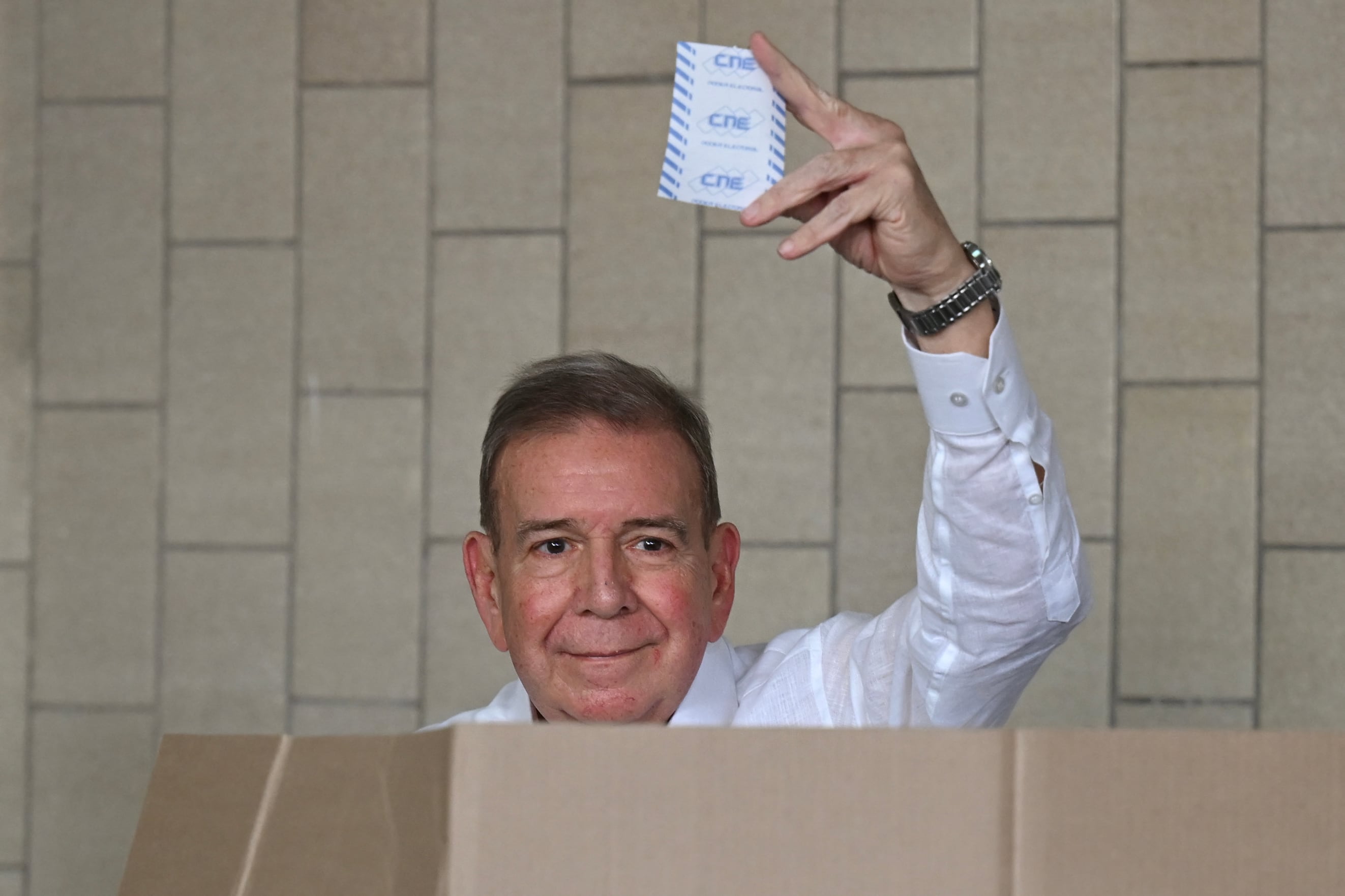 (FILES) Venezuelan opposition presidential candidate Edmundo Gonzalez Urrutia shows his ballot as he votes at the Santo Tomas de Villanueva school in Caracas during the presidential election on July 28, 2024. - Venezuelan prosecutors have summoned opposition leader Edmundo Gonzalez Urrutia for questioning as part of a criminal investigation following a widely questioned presidential election claimed by strongman Nicolas Maduro. (Photo by RAUL ARBOLEDA / AFP)