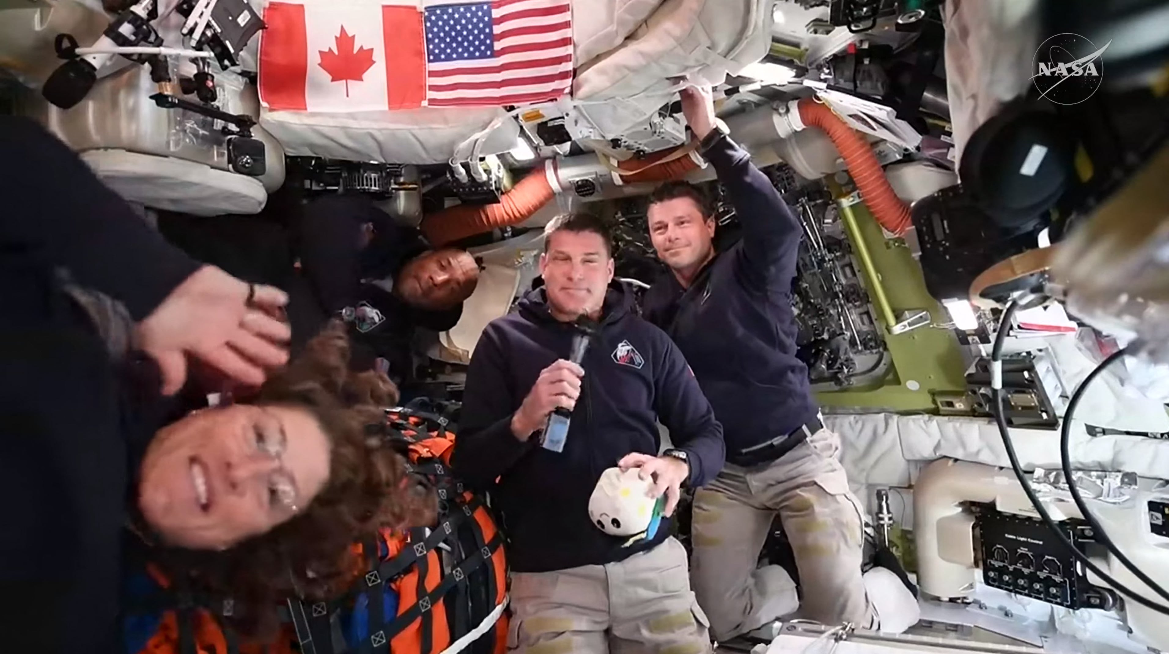 This screengrab from a NASA live broadcast video shows (L-R) NASA astronaut and Artemis II Mission Specialist Christina Koch, NASA astronaut and Artemis II pilot Victor Glover, Canadian Space Agency astronaut Artemis II Mission Specialist Jeremy Hansen and NASA astronaut and Artemis II Commander Reid Wiseman during a press call as they travel to the Moon in the Orion spacecraft, on April 3, 2026. The four Artemis astronauts have passed the halfway point between Earth and the Moon on the way to their planned lunar flyby, NASA said on Friday evening. "You are now closer to the moon than you are to us on Earth," mission control told the astronauts at around 11 pm (0400 GMT), according to the space agency's official live broadcast. (Photo by NASA / AFP) / RESTRICTED TO EDITORIAL USE - MANDATORY CREDIT "AFP PHOTO / NASA" - NO MARKETING NO ADVERTISING CAMPAIGNS - DISTRIBUTED AS A SERVICE TO CLIENTS