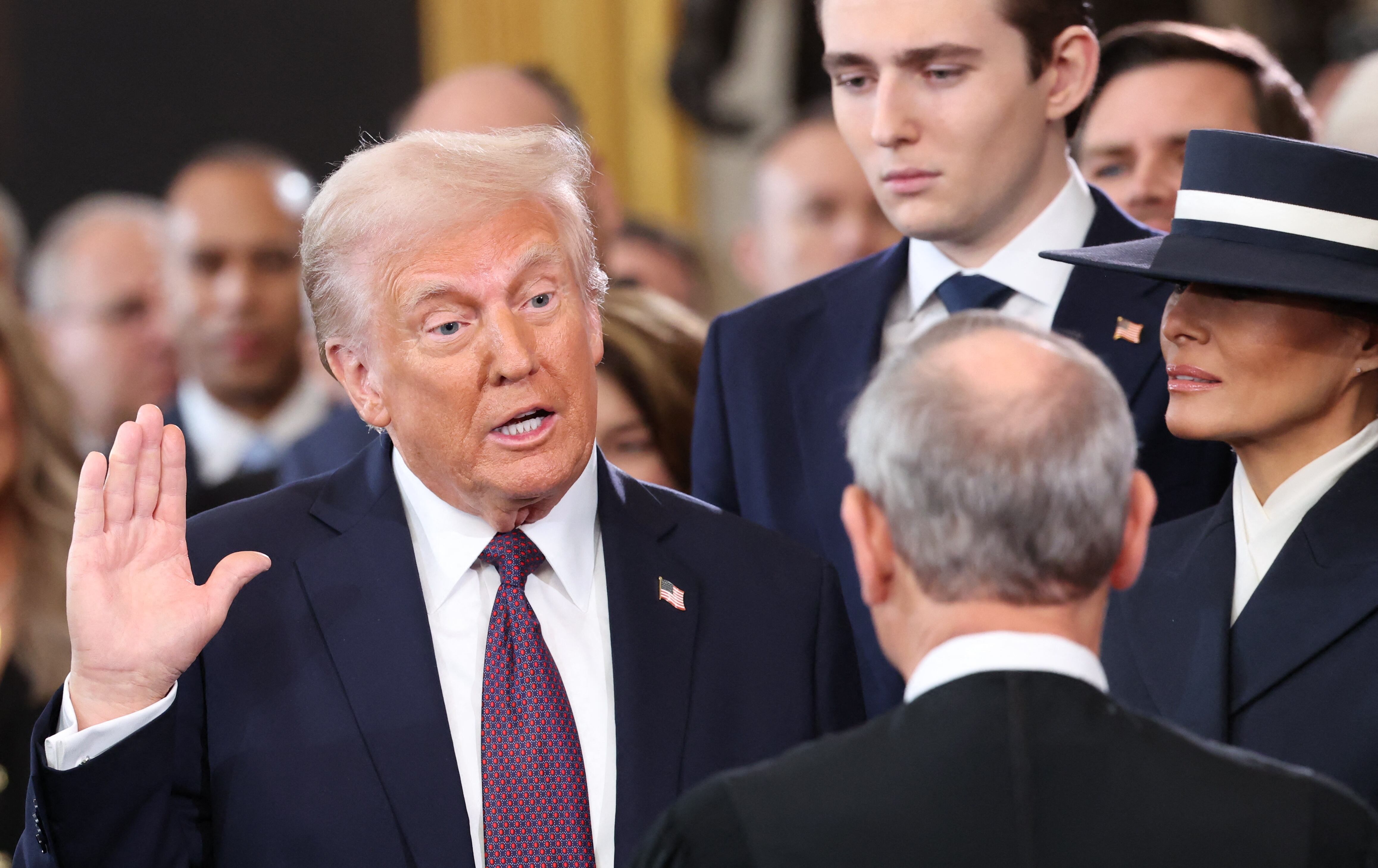 Donald Trump con la mano derecha levantada en signo de juramentación durante su investidura como presidente de los Estados Unidos.