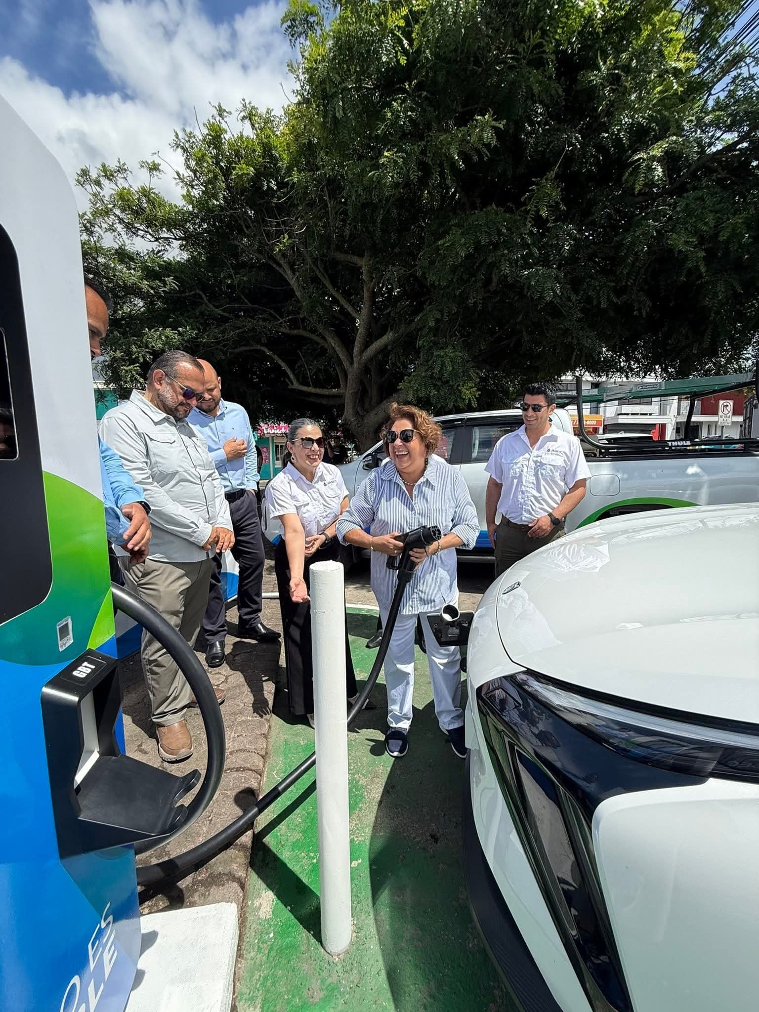 Funcionarios de Jasec inspeccionan la conexión de un vehículo eléctrico a la nueva estación de recarga rápida.