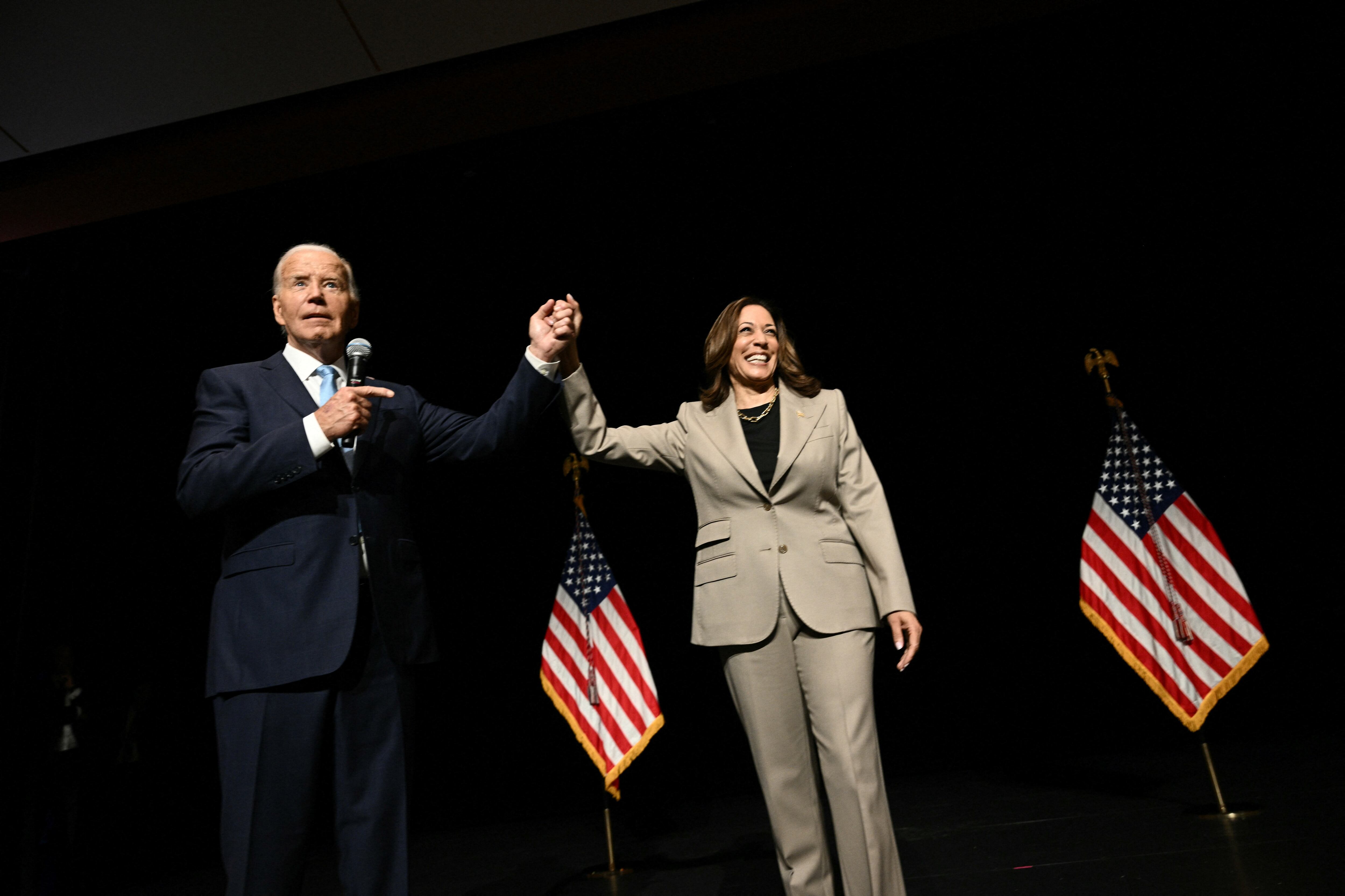 El presidente de EE. UU., Joe Biden, y la vicepresidenta y candidata presidencial demócrata, Kamala Harris, levantan las manos tras un discurso, que dieron este jueves, en el Prince George's Community College en Largo, Maryland. Foto de Brendan SMIALOWSKI / AFP
