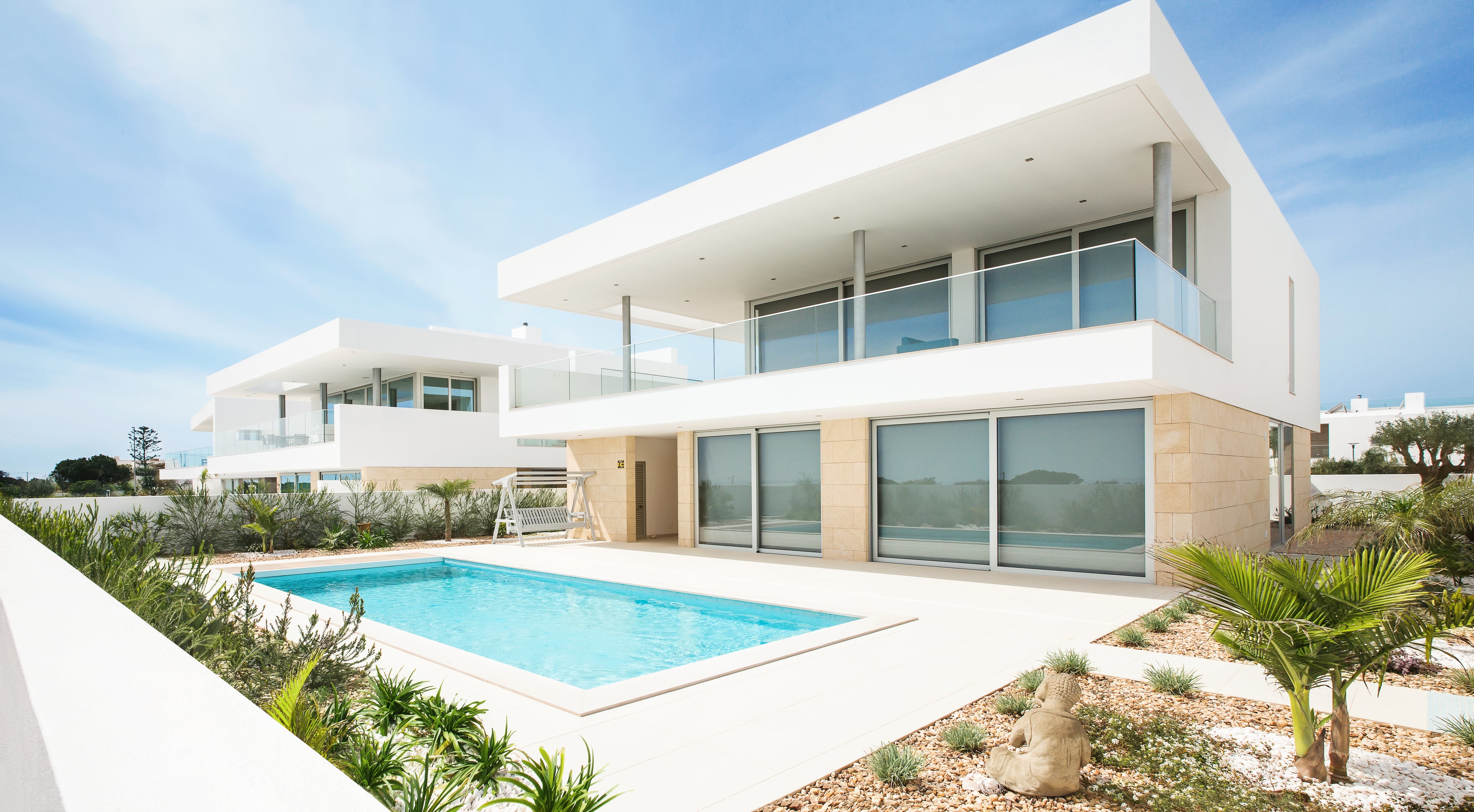 Fachada de una vivienda moderna de lujo con piscina, utilizada de forma regular o recreativa, que podría estar incluida en el pago del impuesto a casas de lujo.