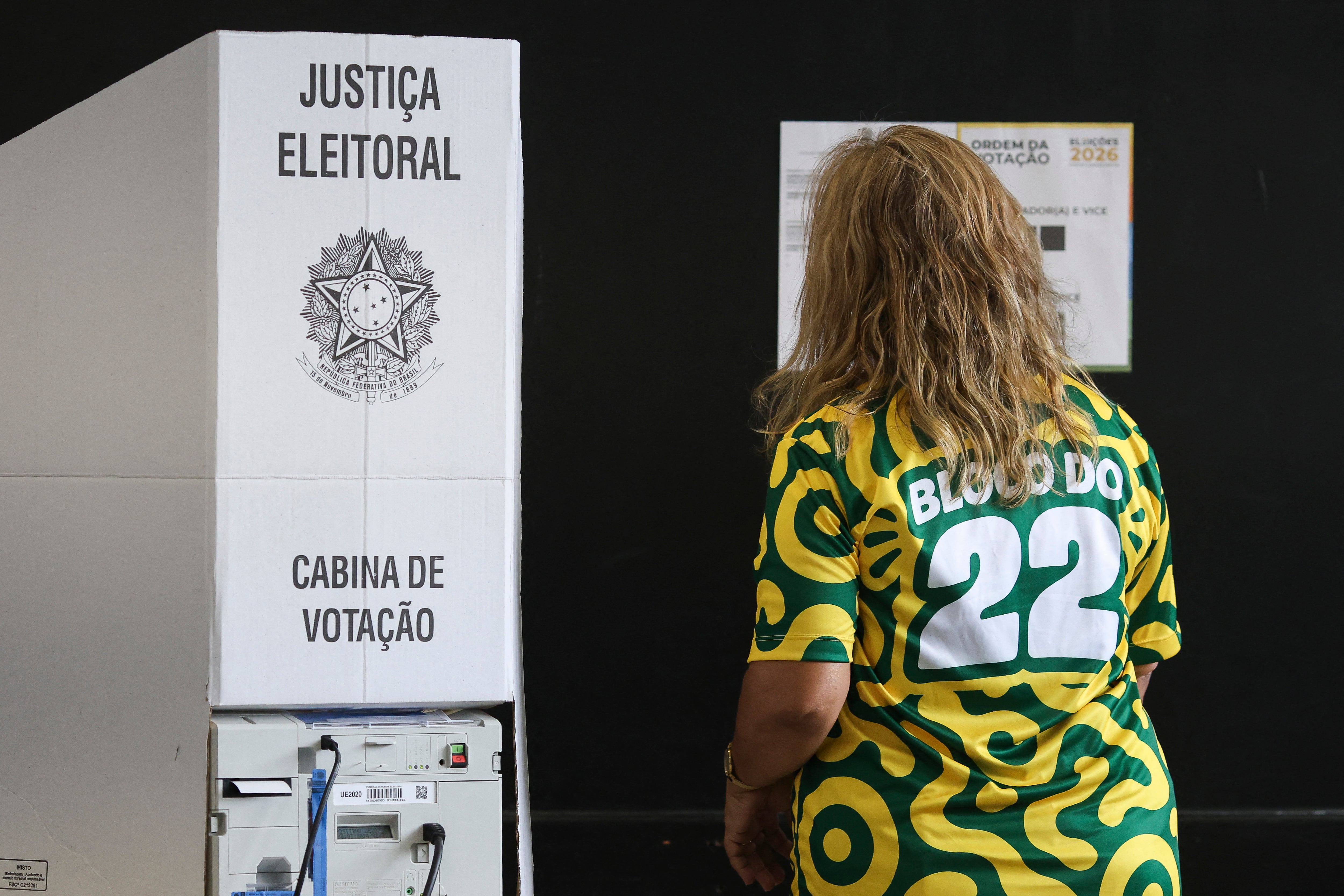 A woman prepares to vote during the presidential runoff election at a polling station in Brasilia, on October 25, 2026. Brazilians head to the polls for a runoff between President Luiz Inacio Lula da Silva and right-wing senator Flavio Bolsonaro that will determine whether Brazil remains one of the few leftist nations in the region or joins a regional swing to the right championed by US President Donald Trump, a Bolsonaro ally. (Photo by Sergio Lima / AFP).