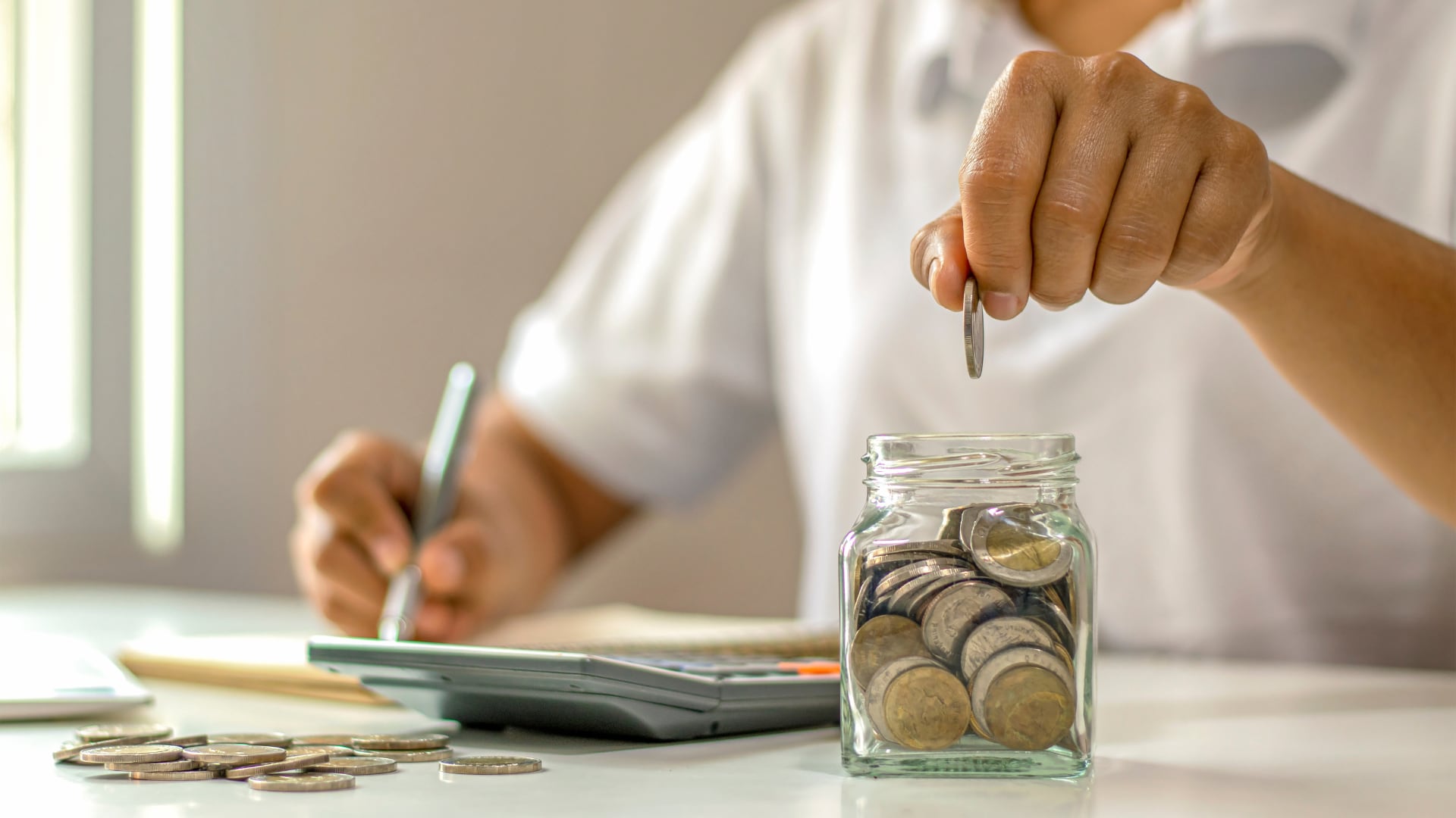 Persona revisando su presupuesto personal con calculadora y documentos financieros en la Semana Mundial del Dinero, promovida por la OCF para fomentar educación financiera y buenas prácticas económicas.