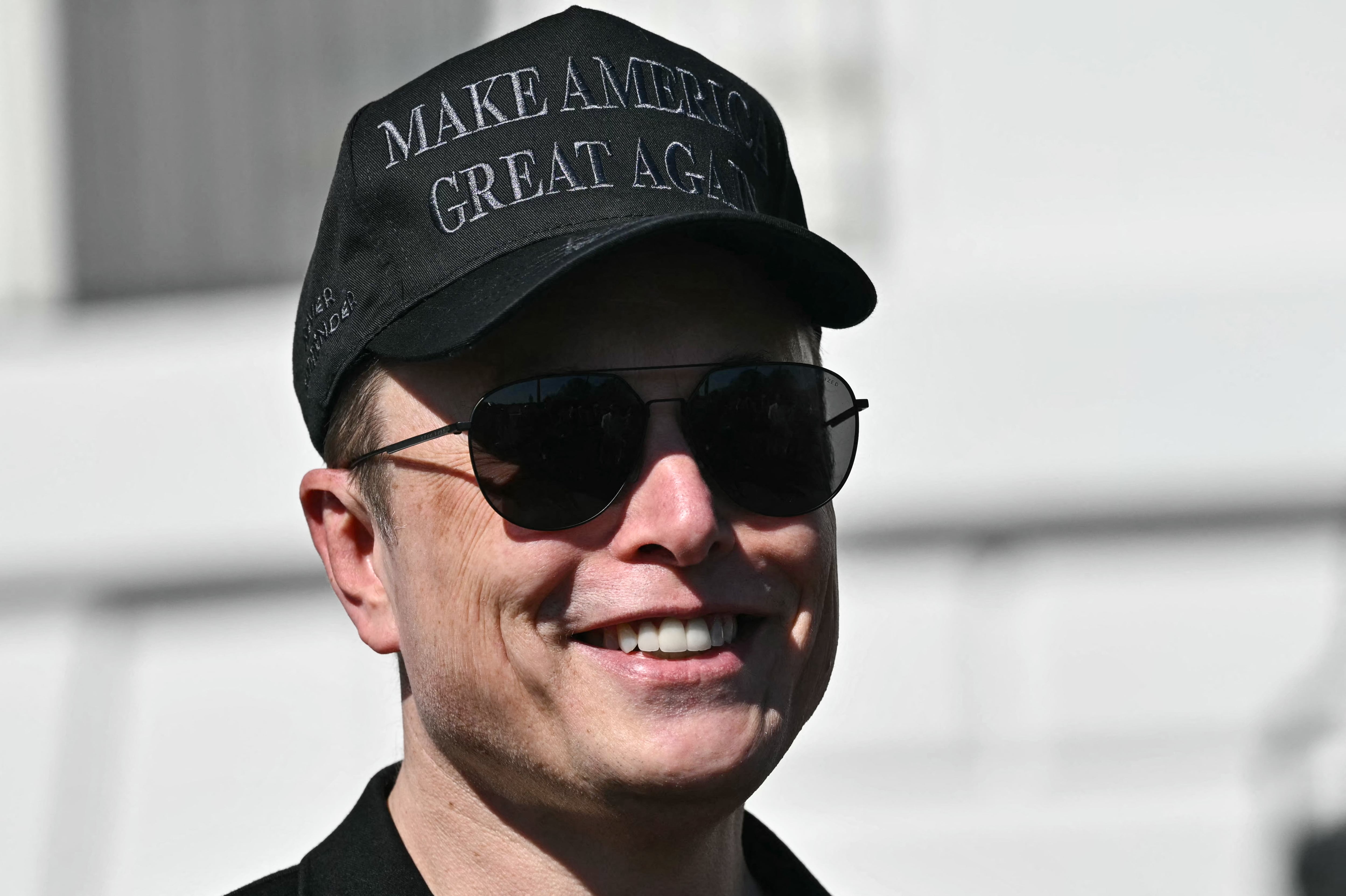 Tesla CEO Elon Musk looks on as US President Donald Trump speaks to the press as they stand next to a Tesla vehicle on the South Portico of the White House on March 11, 2025 in Washington, DC.