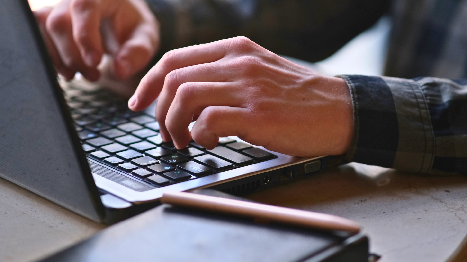 Manos de una persona digitando en computadora portátil para completar el Registro de Transparencia y Beneficiarios Finales del Ministerio de Hacienda