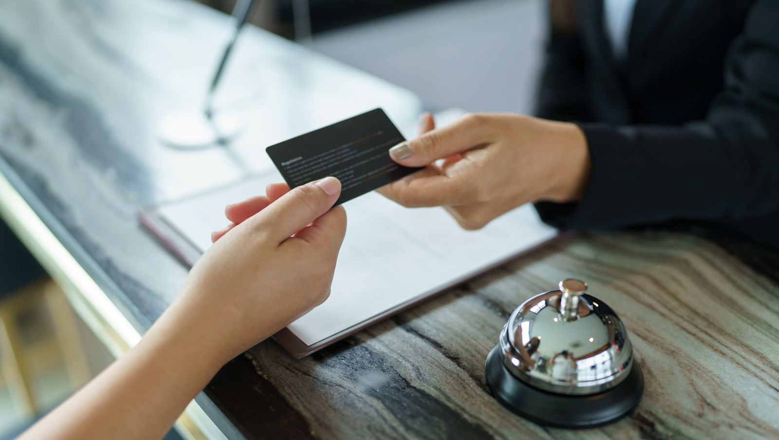 Persona entrega tarjeta en la recepción de un hotel, simbolizando el crecimiento del sector turístico en Costa Rica con la apertura de nuevos desarrollos hoteleros registrados por el ICT.