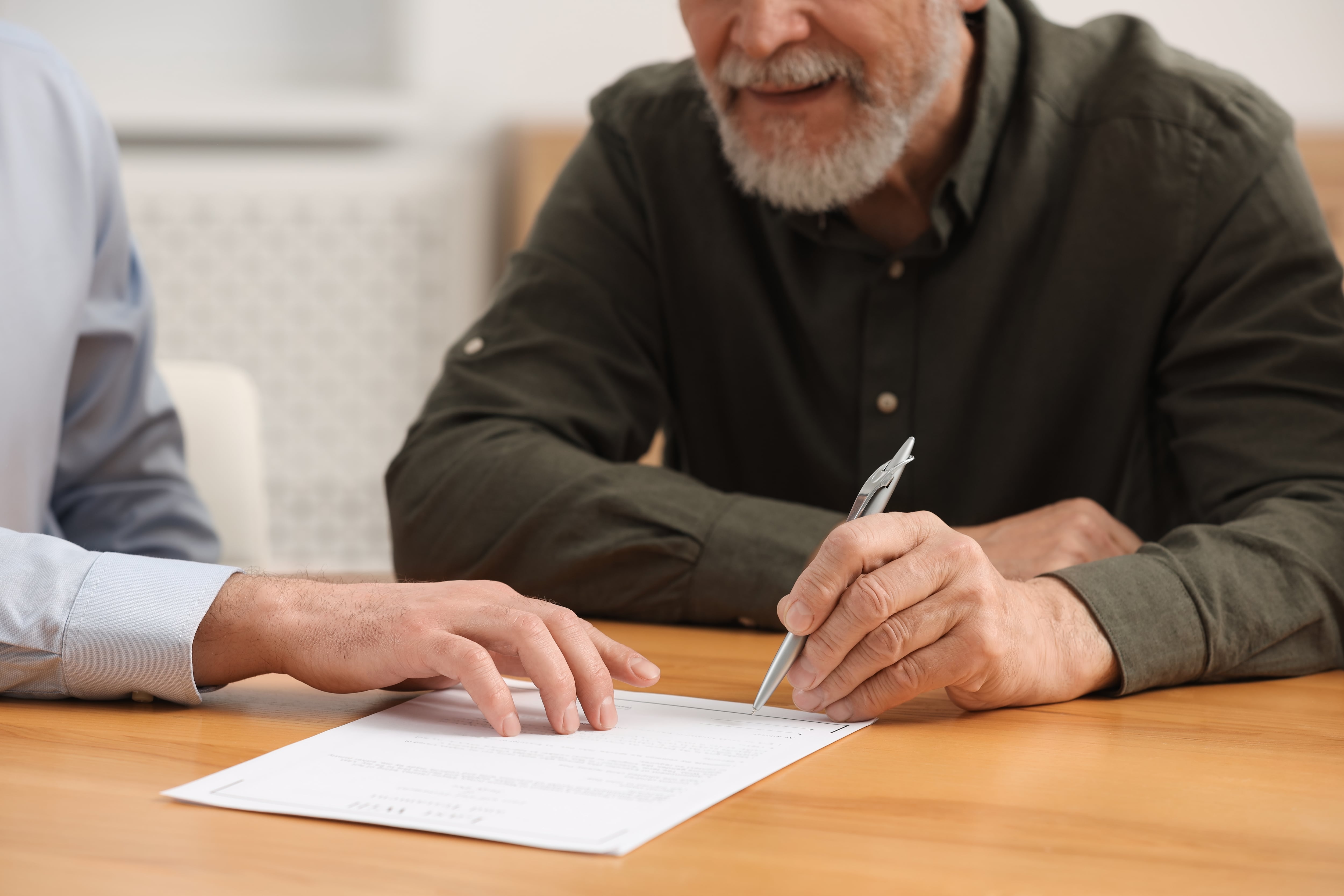 En la imagen, alguien firmando un documento legal