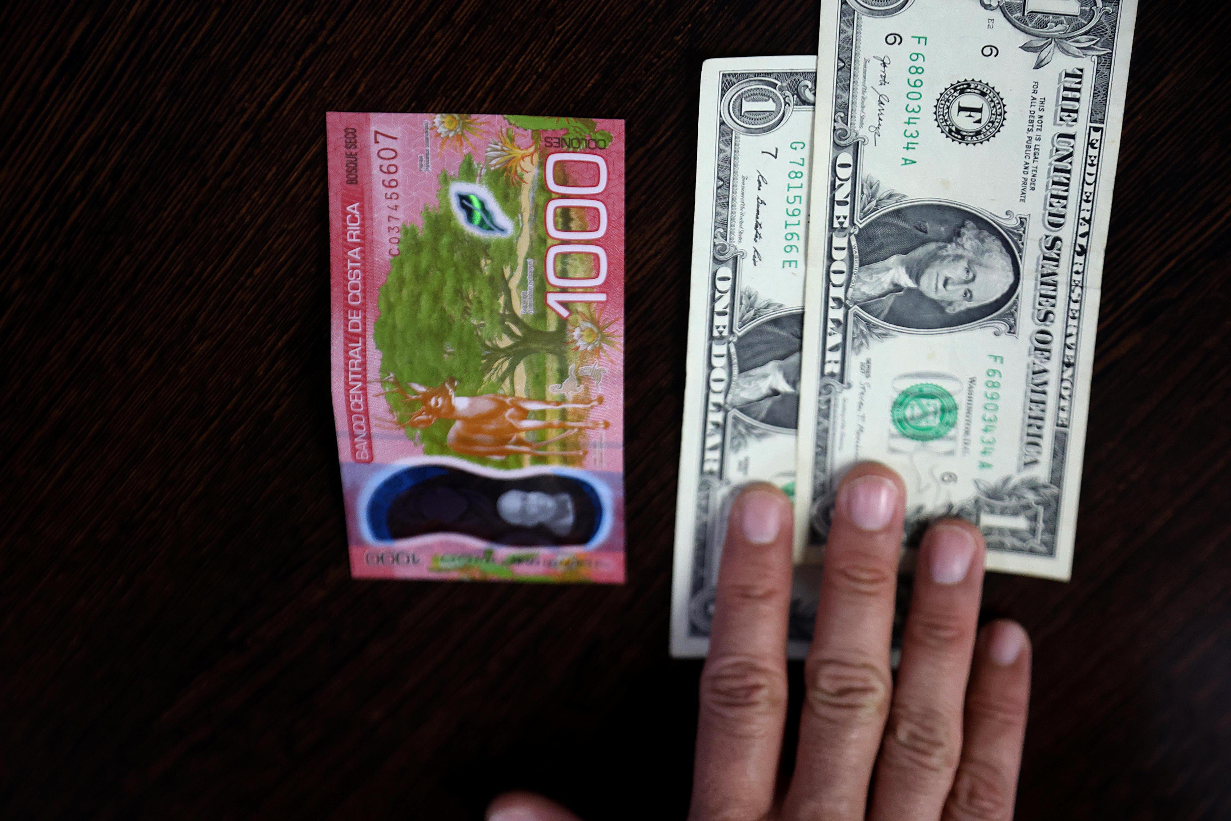 Una persona compra dólares en una entidad financiera.