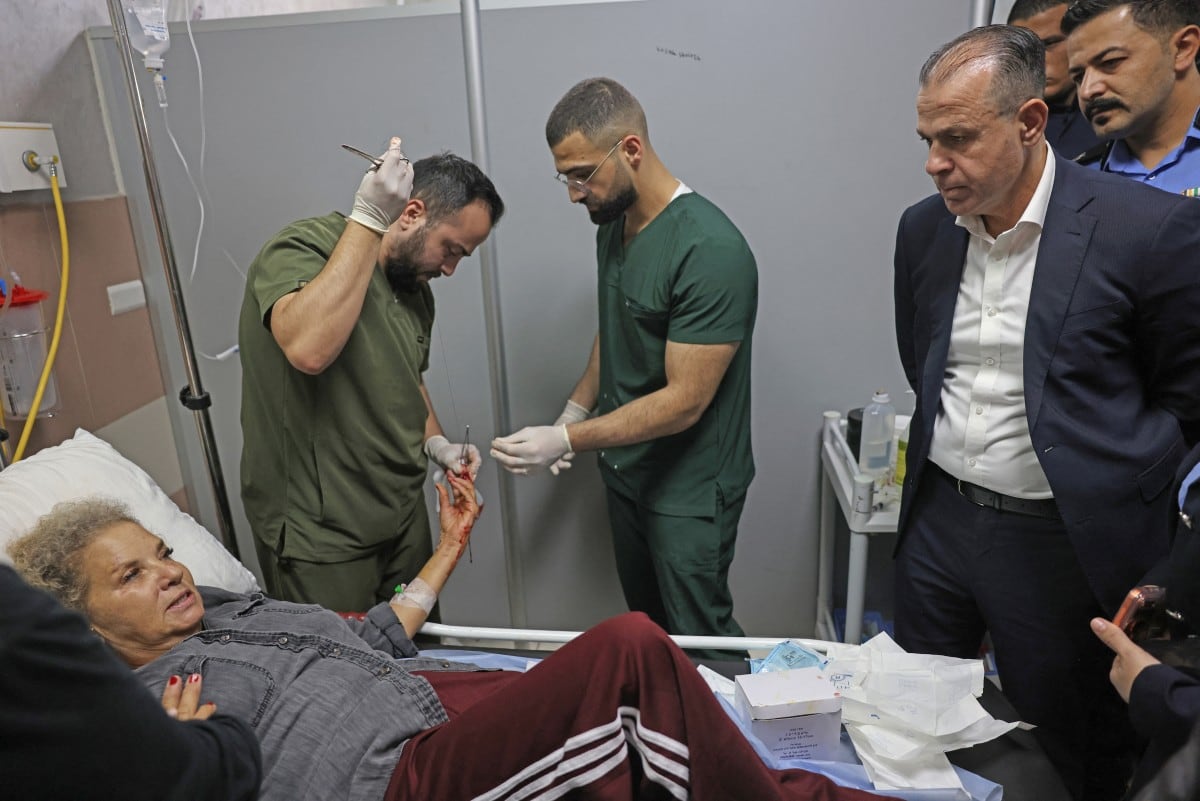 Allam Al-Saqqa (d), director general de la Policía Civil de la Autoridad Palestina, visita a la fotoperiodista estadounidense Heidi Levine, en el servicio de emergencias del hospital de Ramala, ciudad ocupada por Israel.