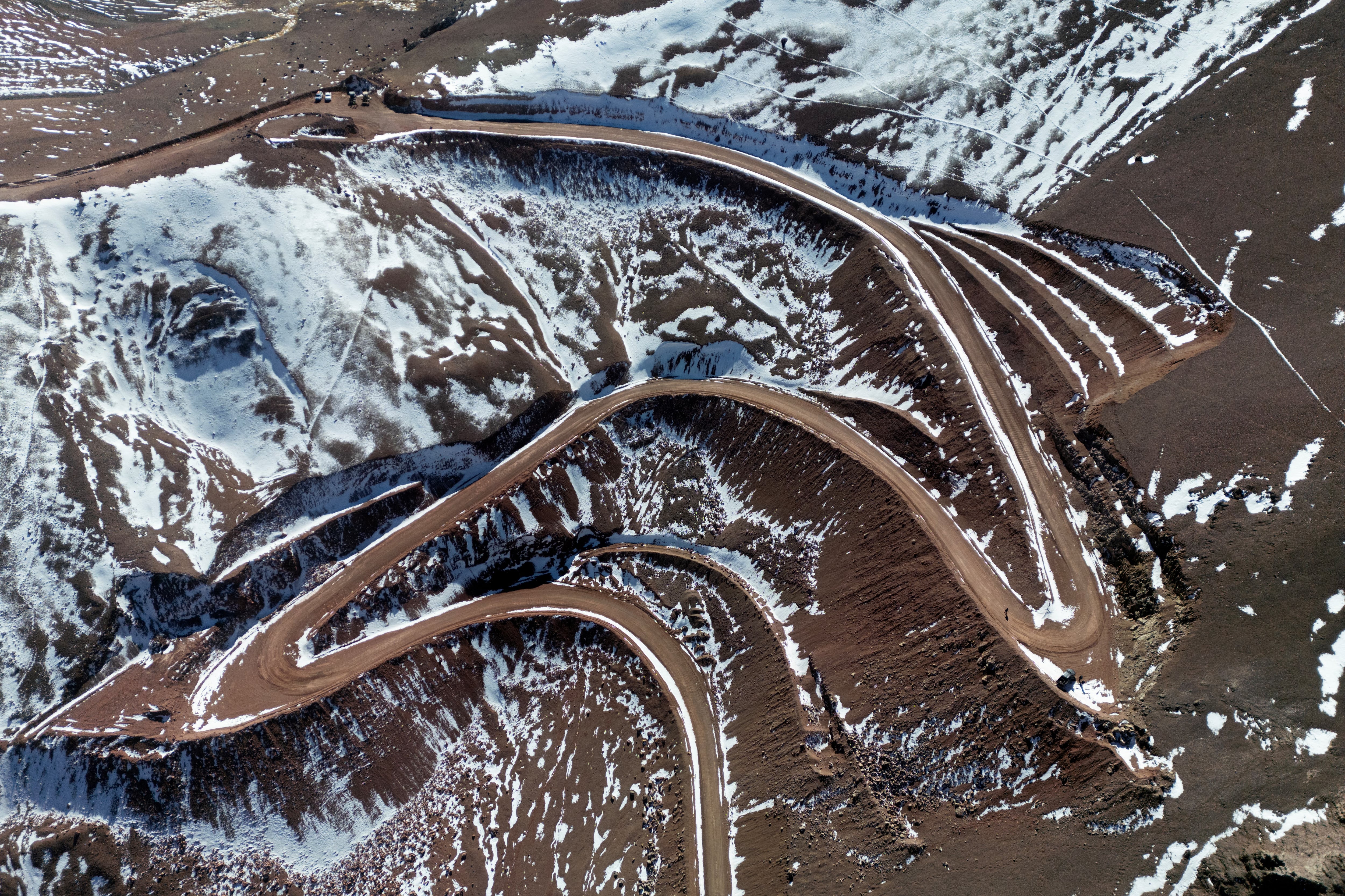 Esta imagen muestra los picos nevados de la cordillera de los Andes con una carretera construida para la exploración minera en Calingasta, provincia de San Juan, Argentina, el 22 de abril de 2026. «La minería se extenderá por toda la cordillera, generando cientos de miles de empleos», predijo el presidente argentino Javier Milei en marzo. Semanas después, promulgó una reforma de la ley de protección de glaciares que permitirá a las provincias abrir nuevas áreas a la minería. Grupos ambientalistas impugnaron la medida ante los tribunales, argumentando que amenaza el acceso al agua.