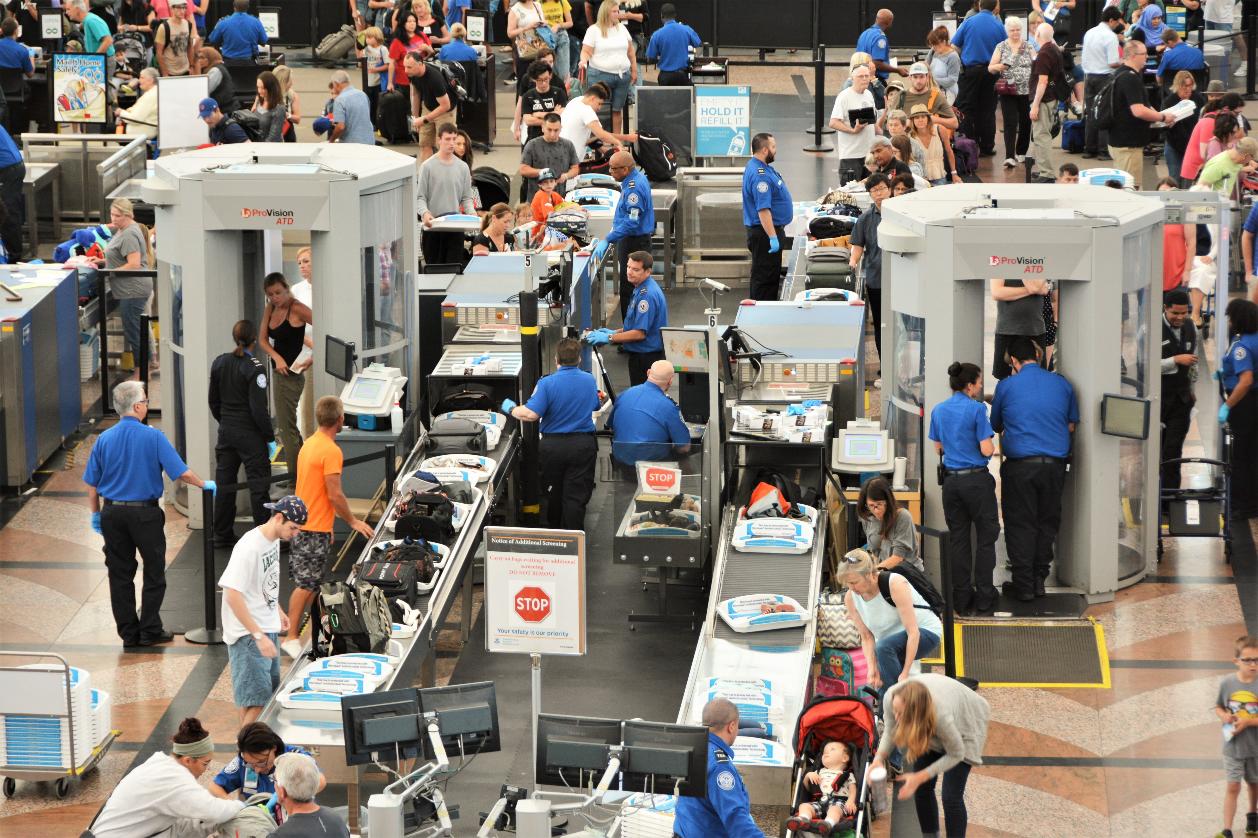 Pasajeros pasando por seguridad en aeropuerto