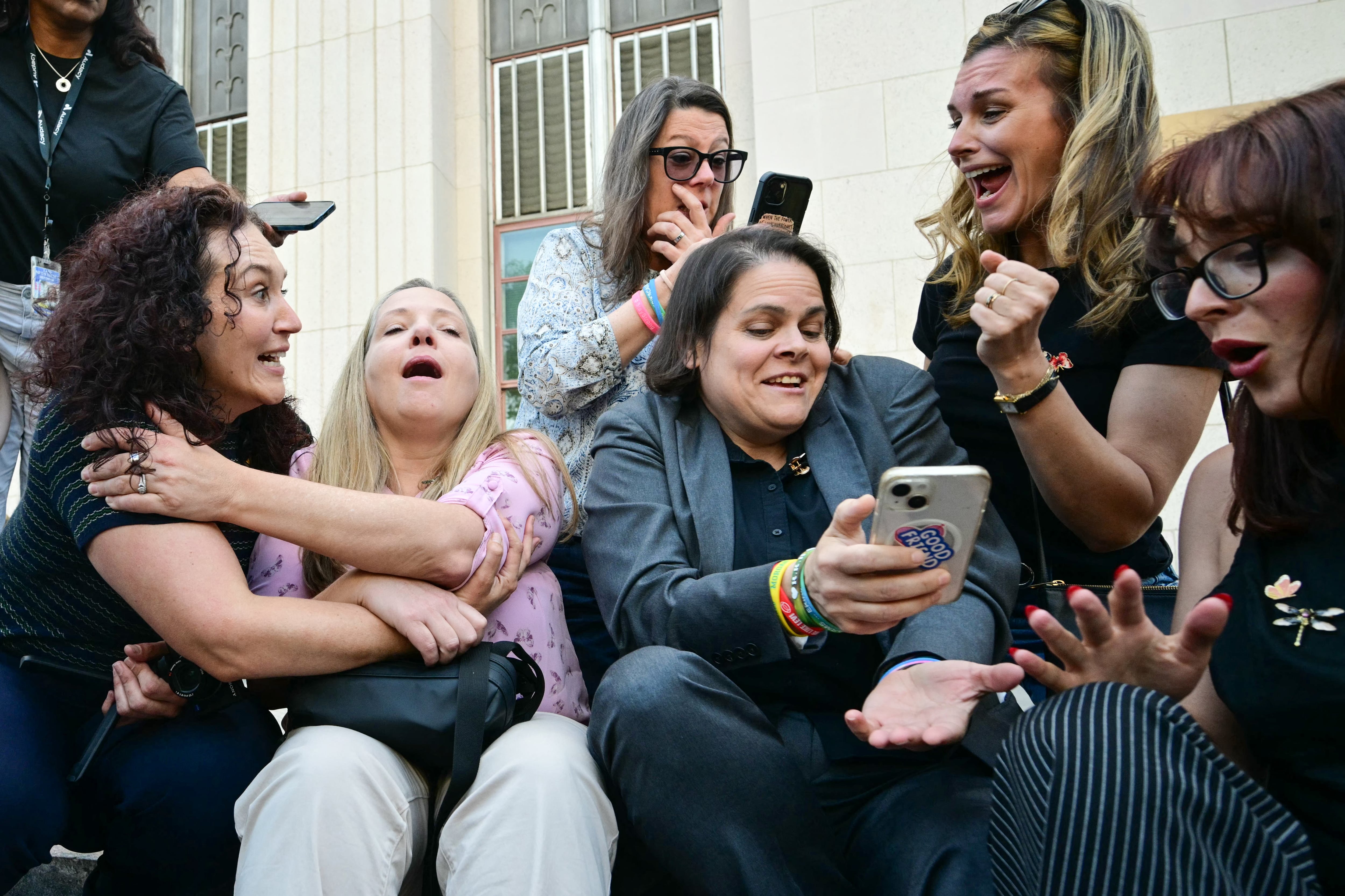 Laura Marquez-Garrett (3R, gray blazer), plaintiffs' attorney for SMVLC (Social Media Victims Law Center), gathers with family members of victims as they react to news that the jury has found Meta and YouTube liable in the social media addiction trial, outside the Los Angeles Superior Court , in Los Angeles, on March 25, 2026. A Los Angeles jury on Wednesday found Meta and YouTube liable for harming a young woman through the addictive design of their social media platforms and ordered the companies to pay $3 million in damages. The decision delivering a landmark verdict that could reshape how the tech industry faces legal accountability for the mental health of young users. (Photo by Frederic J. Brown / AFP)