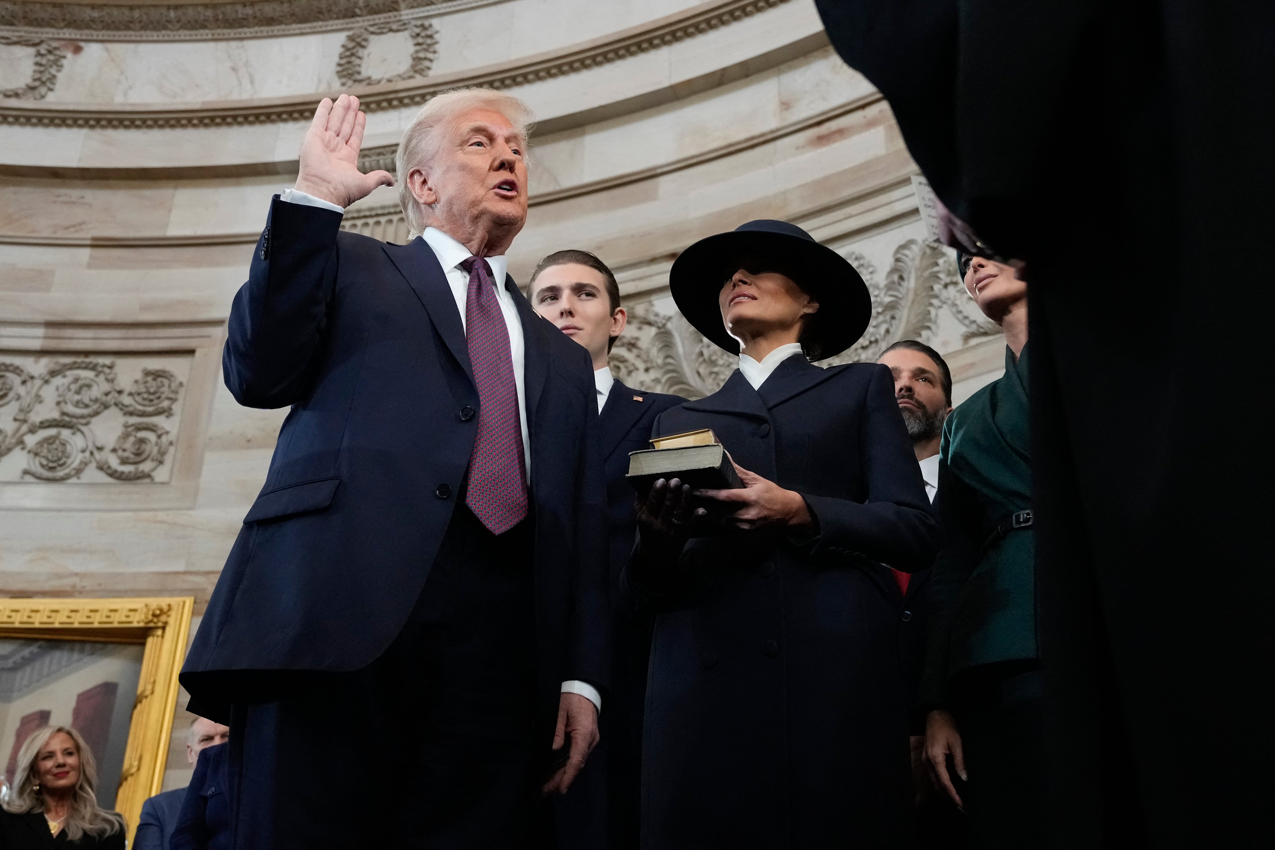 Donald Trump es juramentado como el 47º presidente de los Estados Unidos por el presidente de la Corte Suprema John Roberts mientras Melania Trump sostiene la Biblia durante la 60ª inauguración presidencial en la Rotonda del Capitolio de los Estados Unidos.