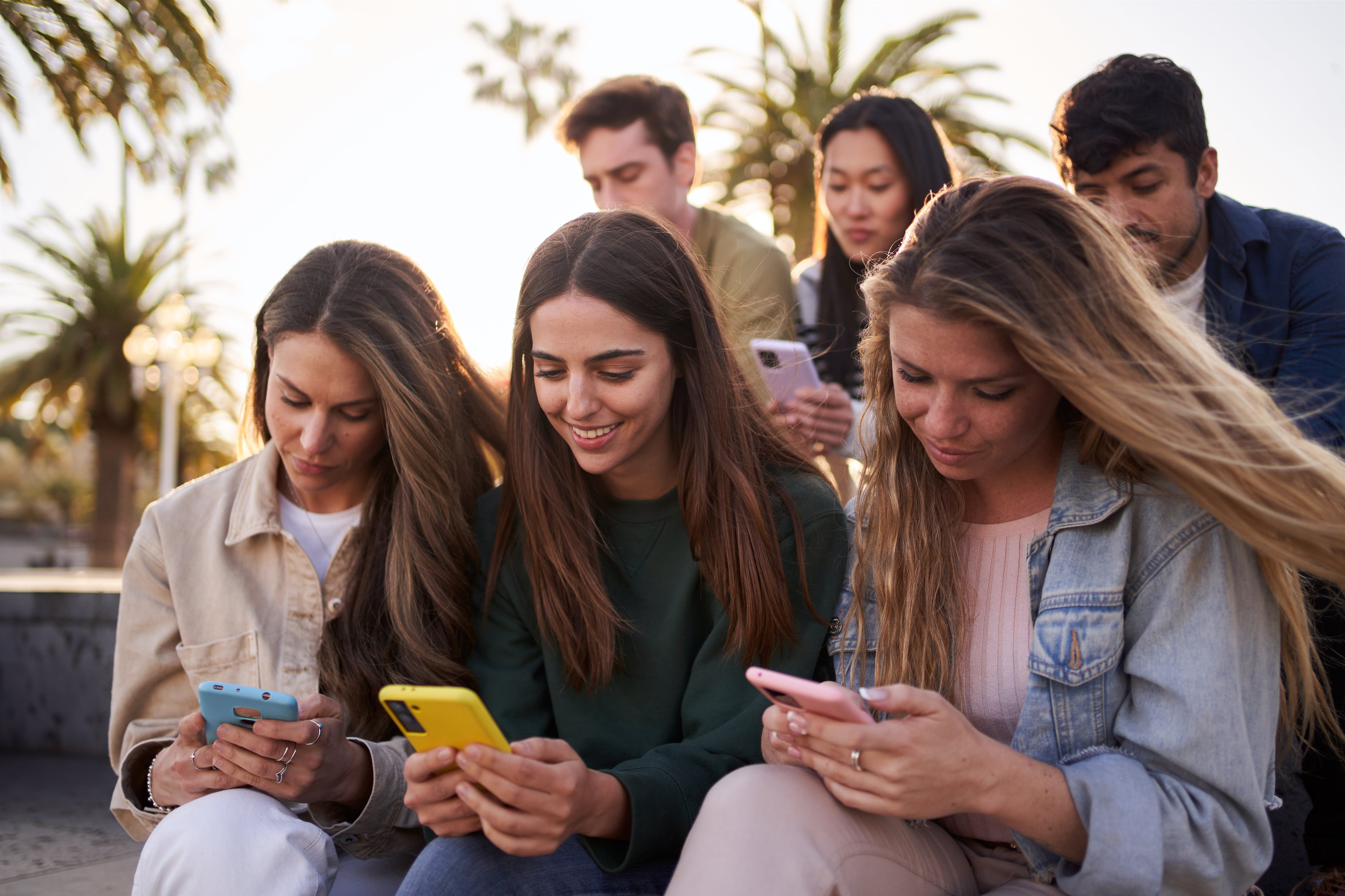 Jóvenes utilizando el teléfono móvil para redes sociales y otros fines.