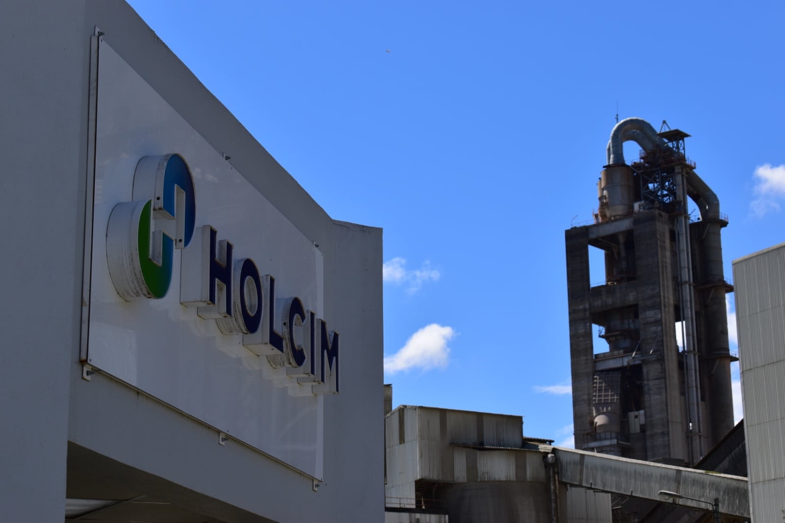 Logo de Holcim con una panorámica de una planta de producción.