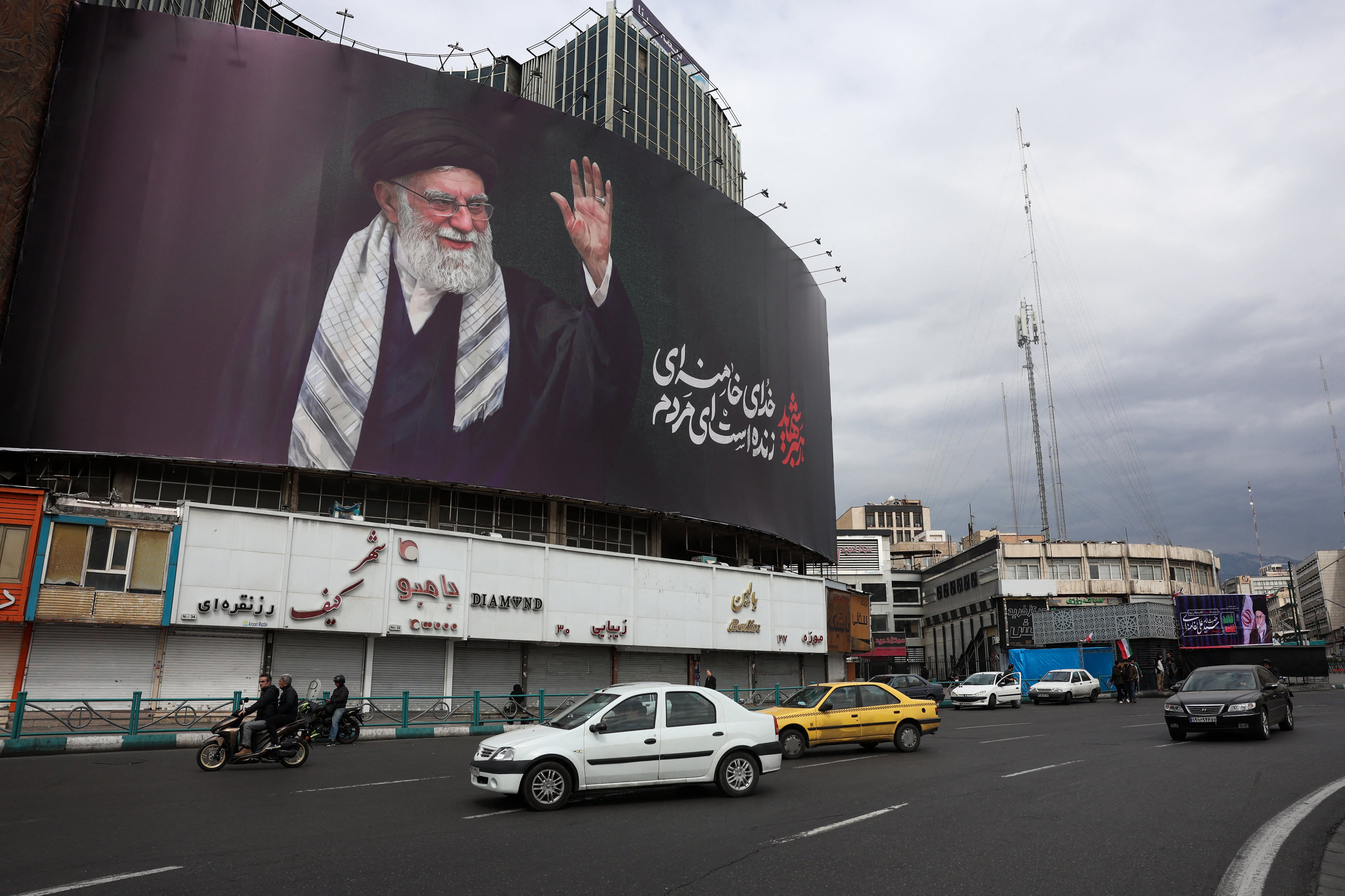Automovilistas pasan frente a una valla publicitaria con la imagen del líder supremo de Irán, el ayatolá Alí Jamenei, en Teherán, el 2 de marzo de 2026. Ese mismo día, bombardeos israelíes en el Líbano dejaron al menos 31 muertos, según las autoridades, tras el lanzamiento de cohetes por parte del grupo militante Hezbolá, respaldado por Teherán, después del asesinato del líder supremo iraní.
