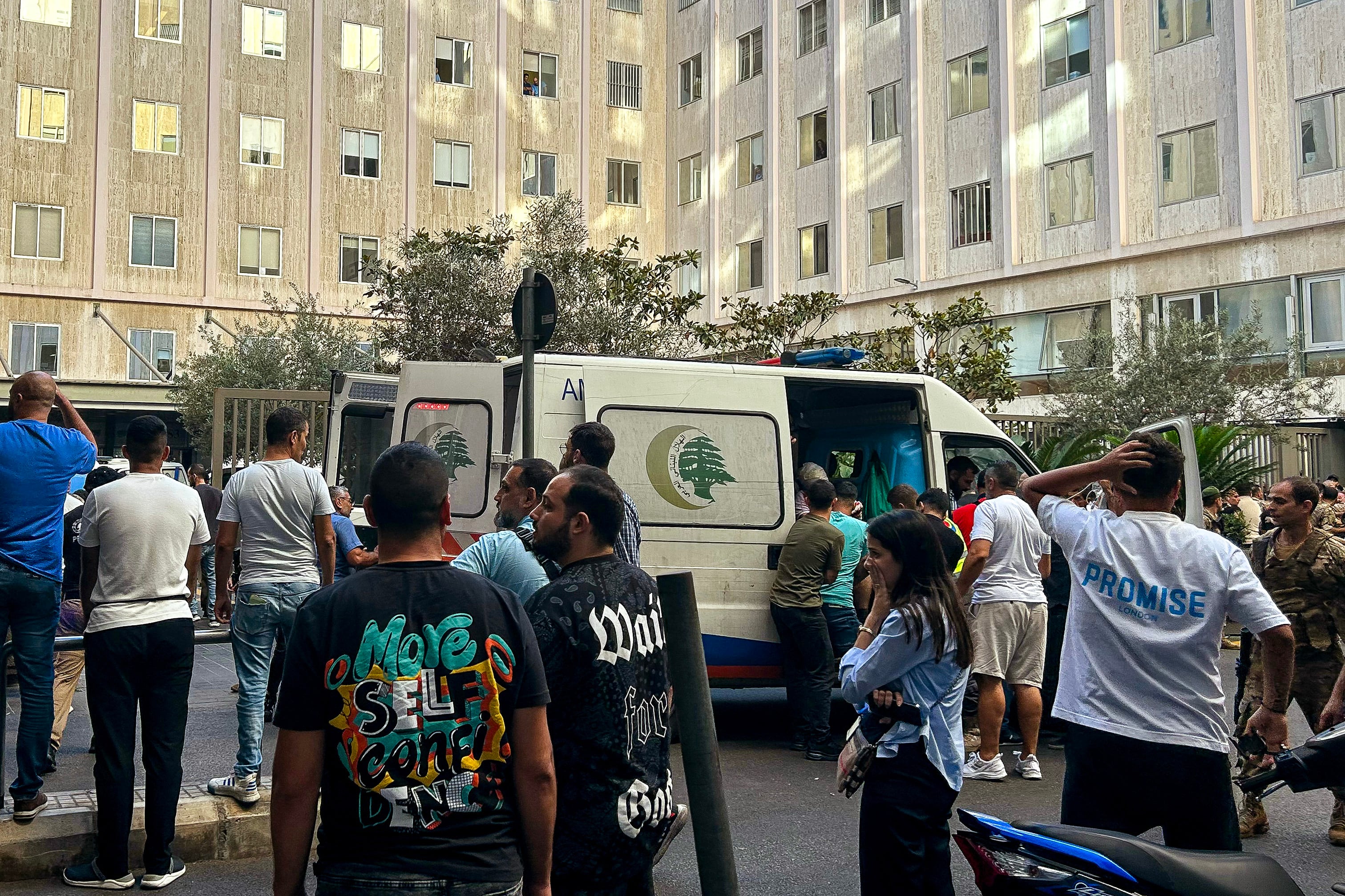 La gente reacciona cerca de una ambulancia mientras los heridos son trasladados a un hospital en Beirut, después de que se produjeran explosiones en varios bastiones de Hezbolá en todo el Líbano