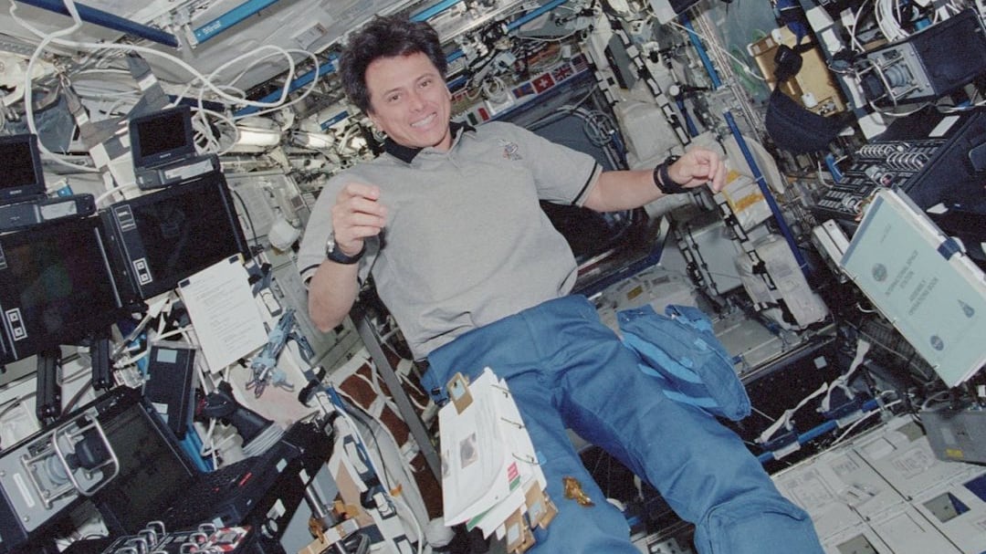 El especialista en misión (MS) STS-111 UF-2, Franklin Chang-Diaz, sonríe mientras posa entre las estaciones de trabajo robóticas en el laboratorio estadounidense Destiny de la Estación Espacial Internacional (ISS).
