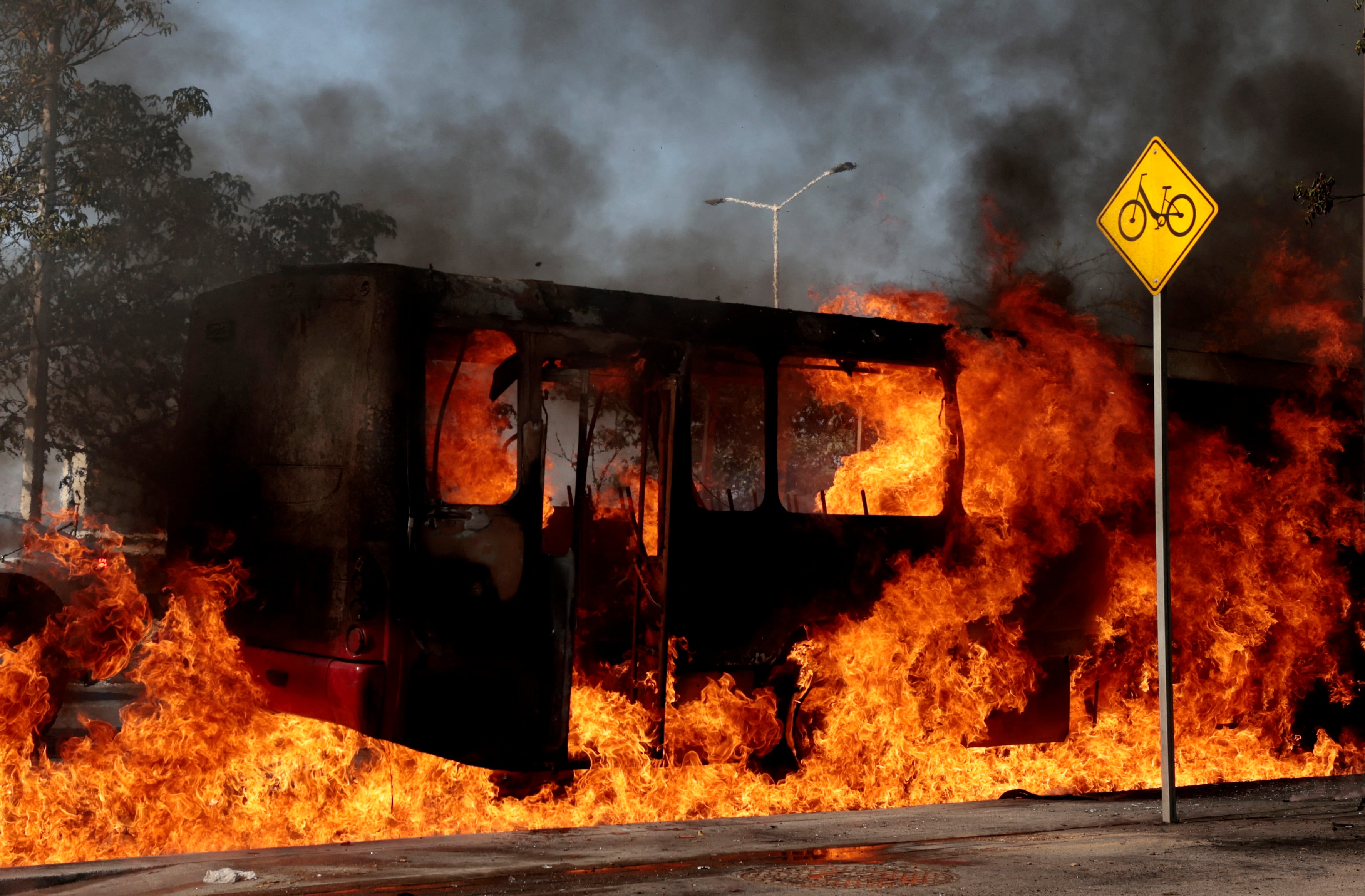 A bus set on fire by organised crime groups in response to an operation in Jalisco to arrest a high-priority security target, burns at one of the main avenues in Zapopan, state of Jalisco, Mexico, on February 22, 2026. Armed civilians blocked several roads in the state of Jalisco, in western Mexico, following an operation by federal forces in the town of Tapalpa, local authorities reported. Jalisco, which will host four matches of the upcoming 2026 World Cup, is home to the powerful Jalisco New Generation Cartel (CJNG), and has been rocked by several episodes of violence in recent years. (Photo by Ulises Ruiz / AFP)