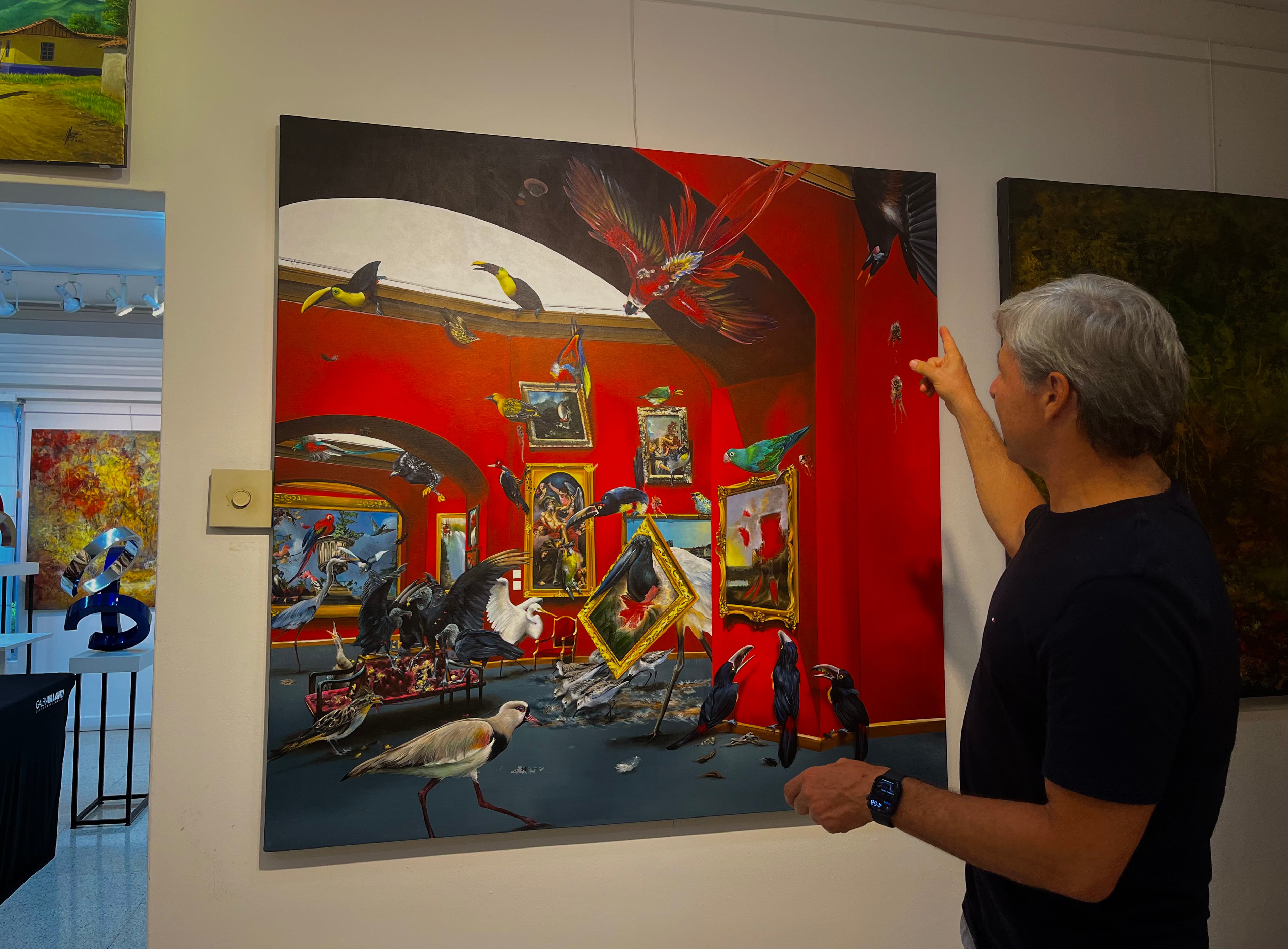 Observar una obra en línea y después en persona es uno de los métodos de venta más utilizados. En la imagen Francisco Castro, vicepresidente de Galería Valanti, junto a la obra "Museo de Historia Natural", de Melissa Matamoros.