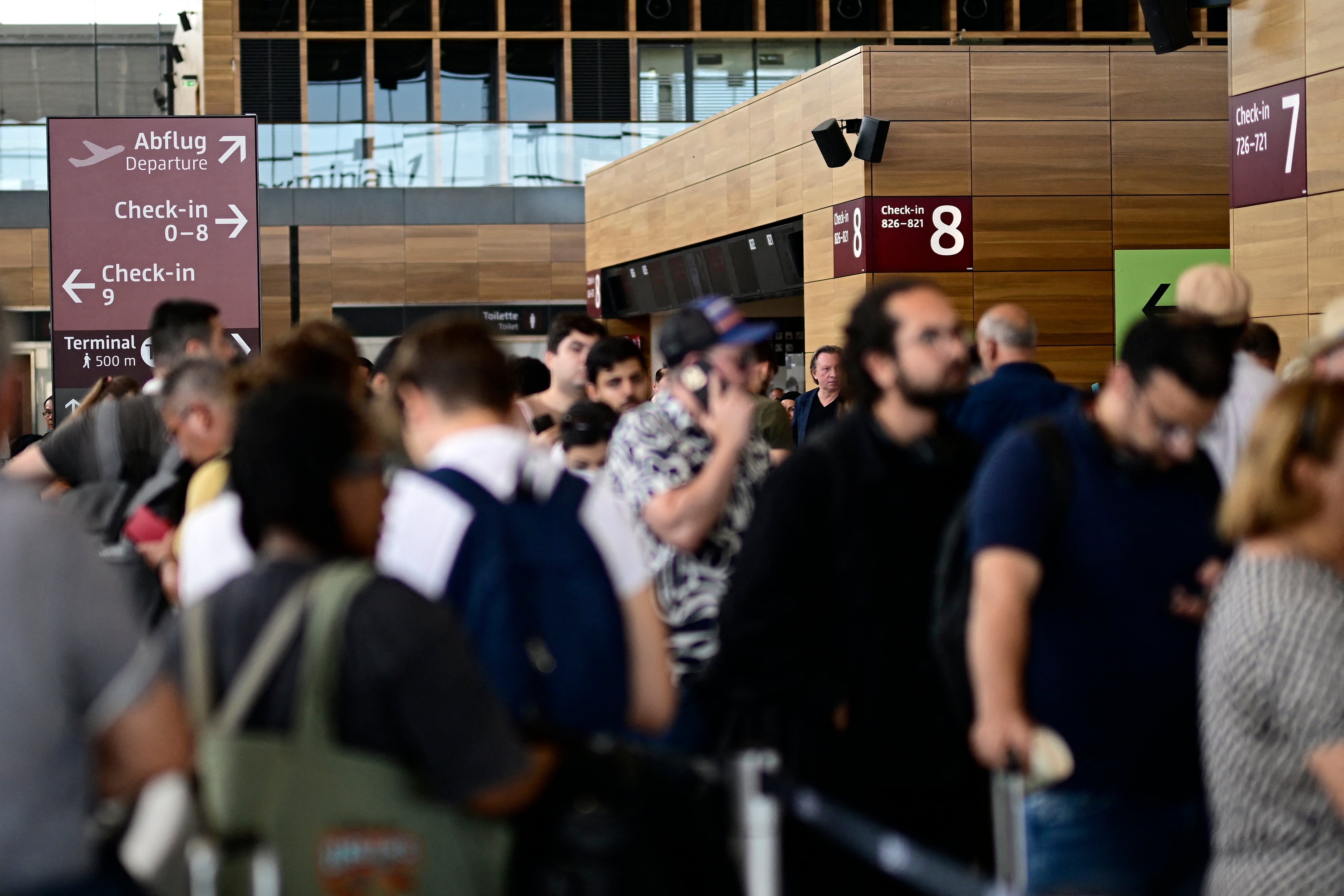 Pasajeros hacen fila para facturar en la Terminal 1 del Aeropuerto Willy-Brandt de Berlín-Brandeburgo (BER) en Schoenefeld, al sureste de Berlín, el 20 de septiembre de 2025, después de que importantes aeropuertos europeos se vieran afectados por una "interrupción cibernética" que afectó a los sistemas automatizados de facturación y entrega de equipaje, causando retrasos. Al menos tres aeropuertos europeos con mucha actividad informaron sobre interrupciones y advirtieron sobre retrasos y cancelaciones de vuelos. (Foto de Tobias SCHWARZ / AFP)