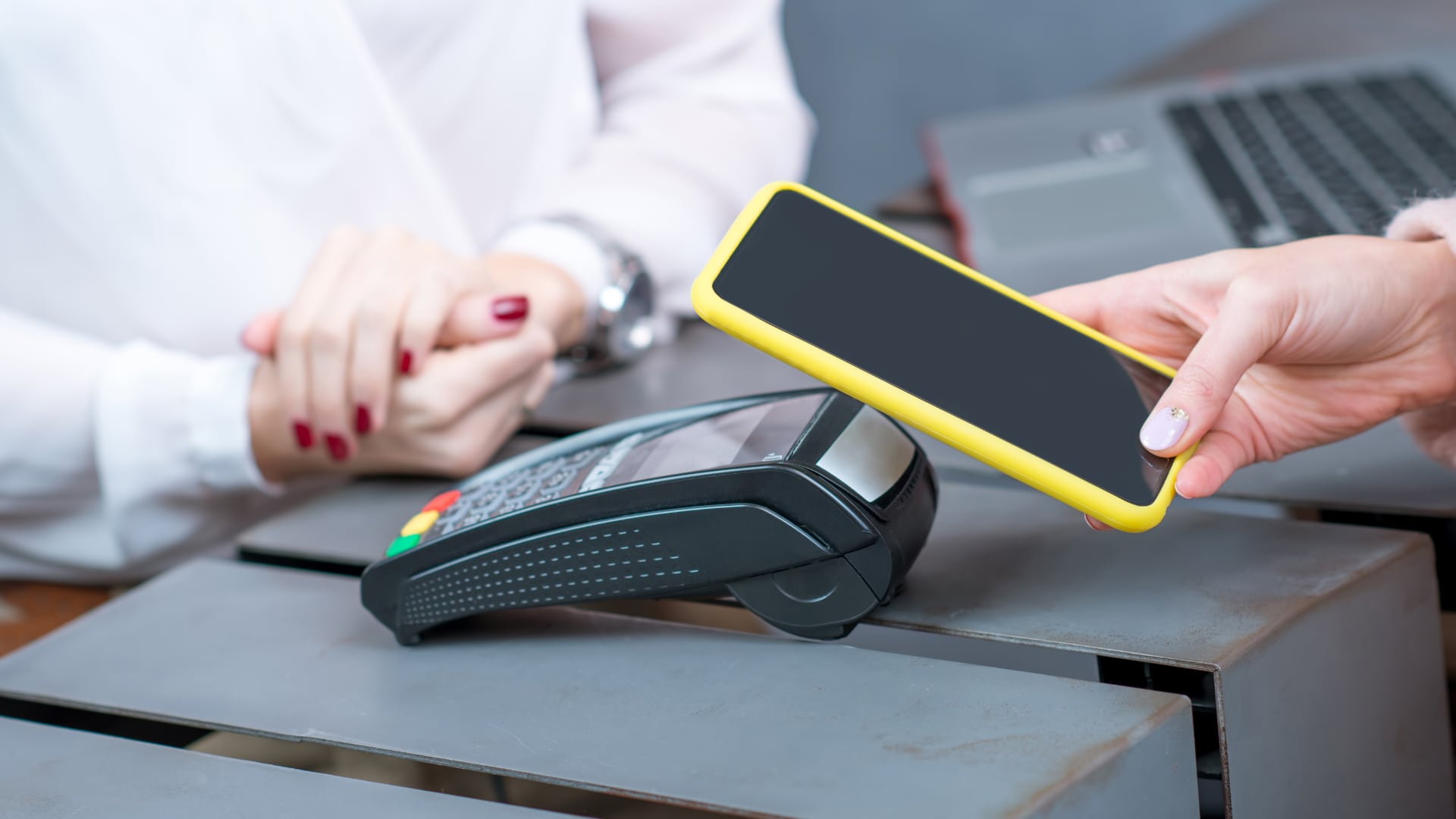 Persona acercando su celular a un datáfono para realizar un pago sin contacto con Google Wallet o Apple Wallet en Costa Rica.