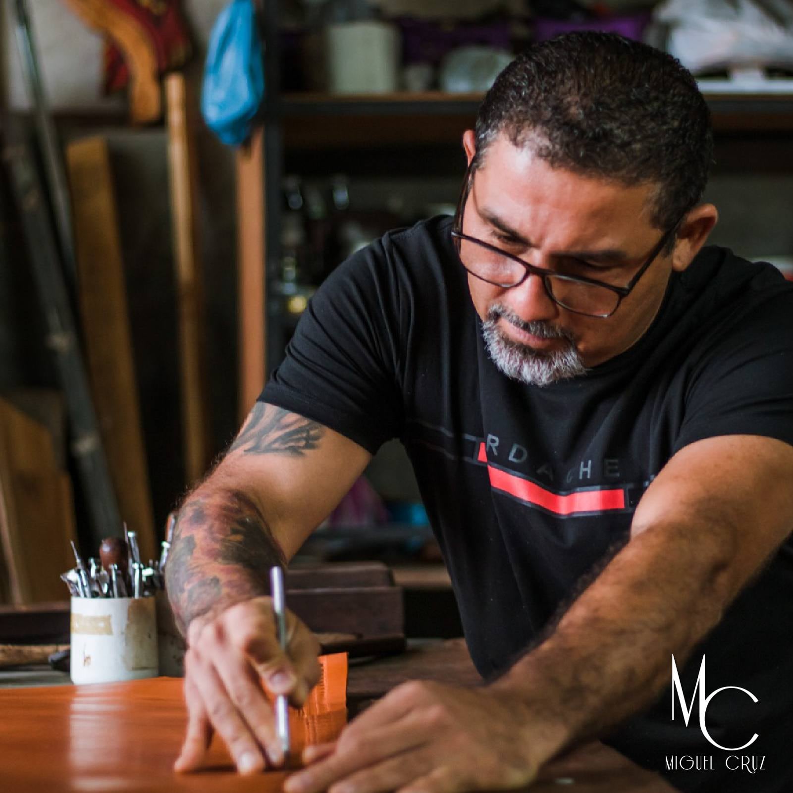 Miguel Cruz Salazar jamás se imaginó que un bolso hecho con sus propias manos, en su taller de San Mateo de Alajuela, iba a terminar en el hombro del actor Brad Pitt… ¡y en el cine mundial!