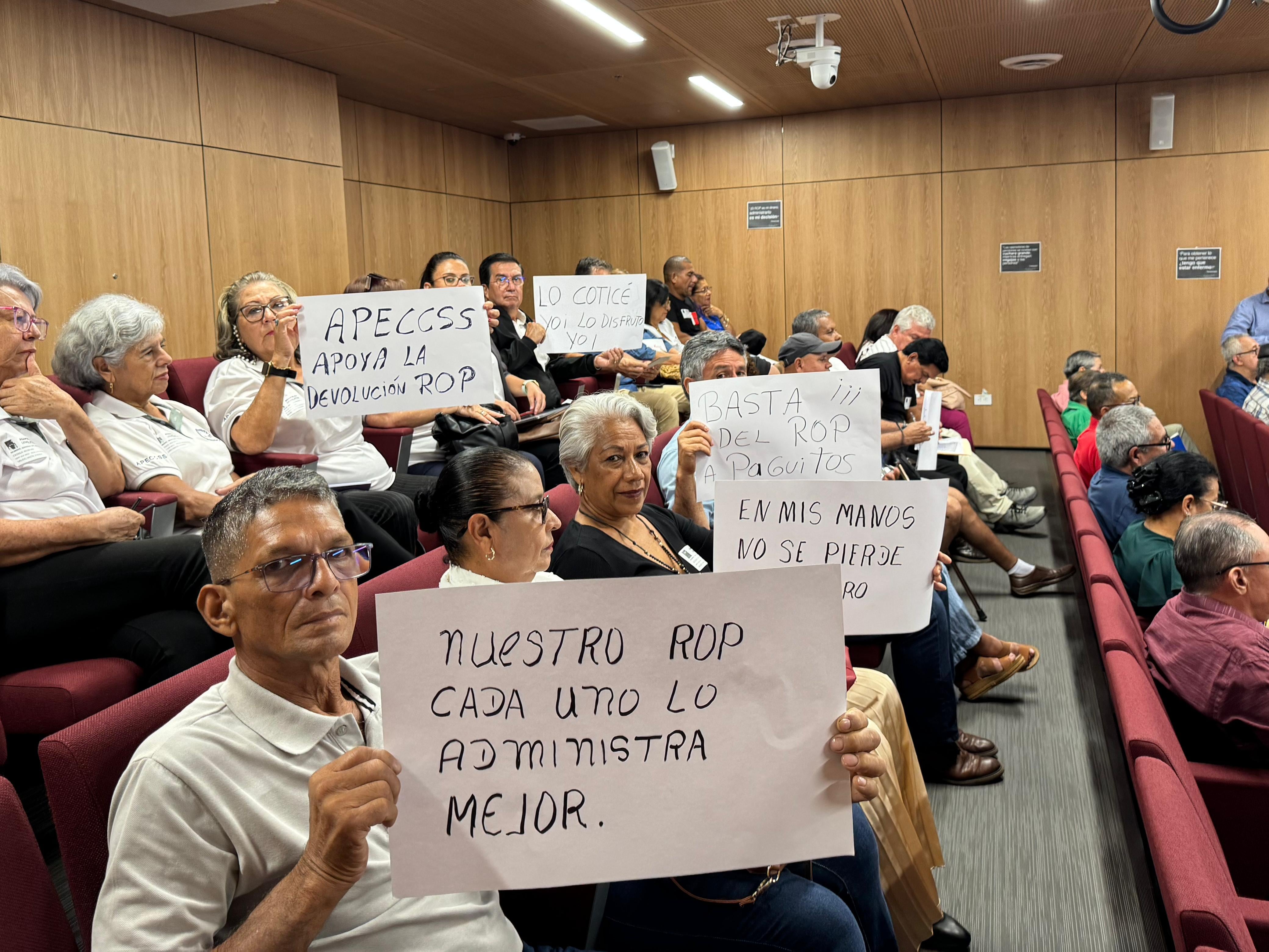 Integrantes del Movimiento Nacional por los Derechos del ROP, desplegaron letreros con distintas consignas, durante la presentación del proyecto de ley de la diputada Ada Acuña.