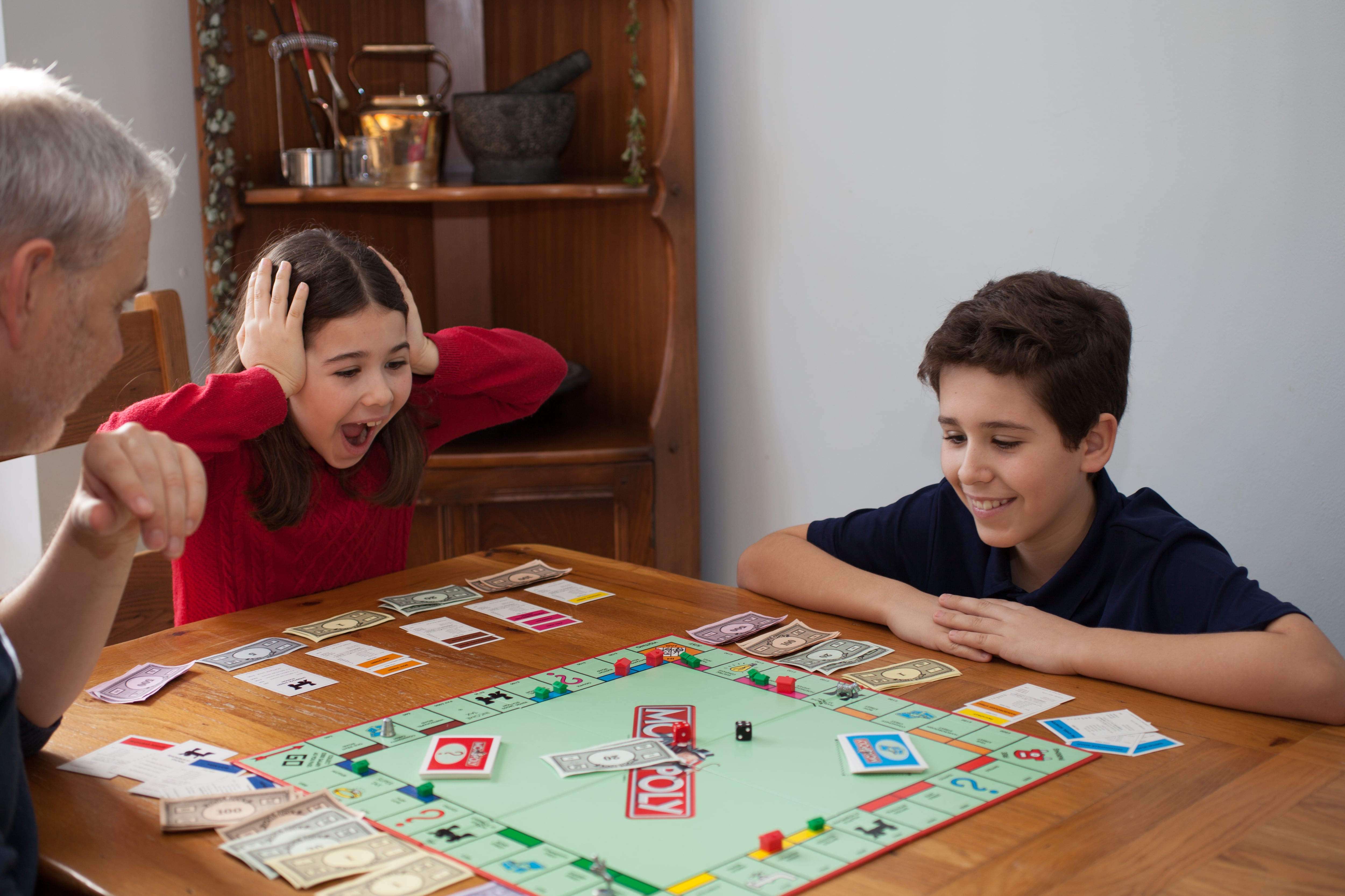 Familia jugando Monopoly, juegos de mesa, jugar en familia, juegos de mesa en casa