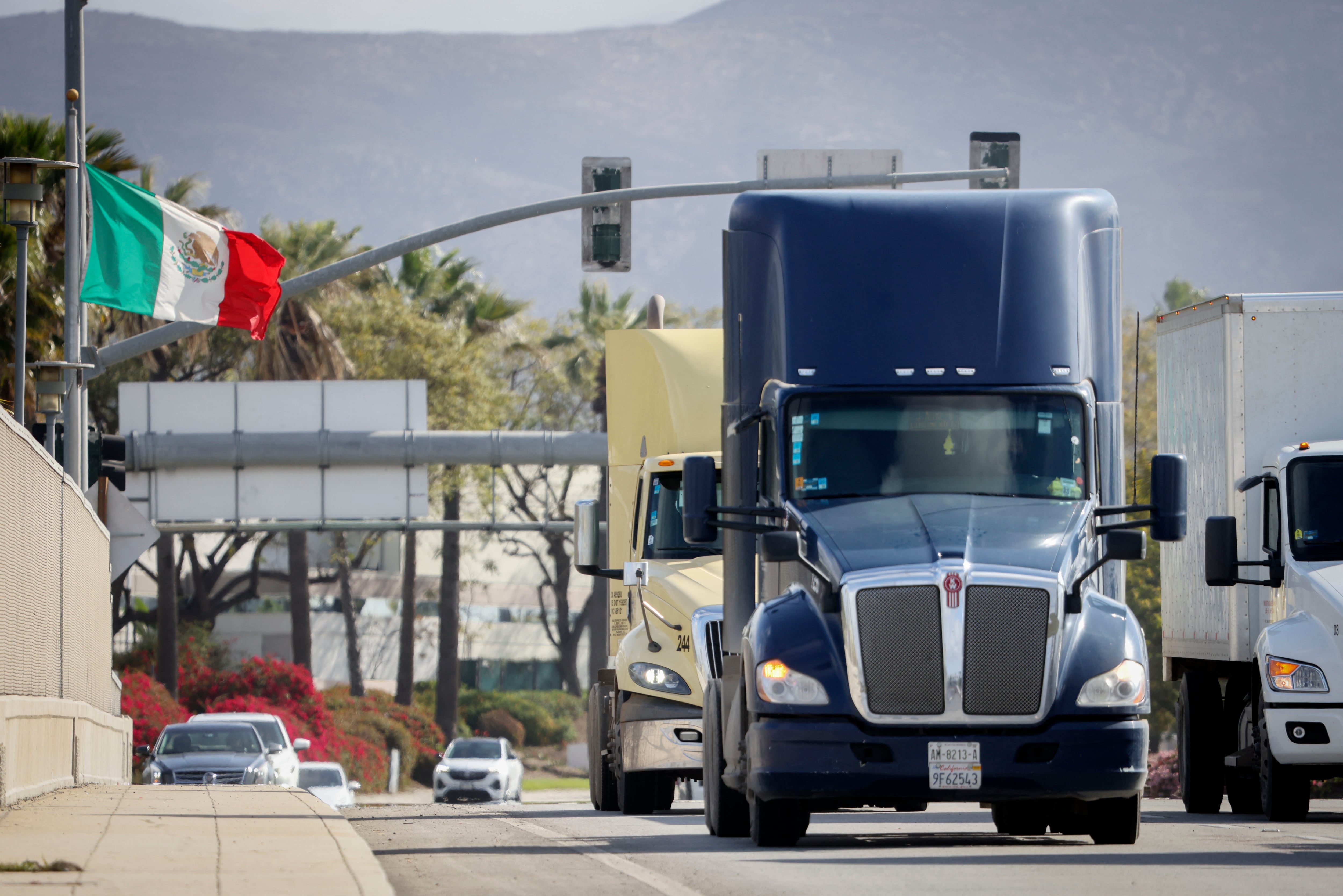 Trucks coming from Mexico enter the United States to an inspection station after crossing the border in Otay Mesa, California, on April 1, 2025. US President Donald Trump kept the world's leading economies on edge on April 1, 2025 as he made final preparations for a "Liberation Day" announcement of sweeping new tariffs that could trigger a global trade war. Trump has promised to be "very kind" when he unveils the so-called reciprocal tariffs on Wednesday, but uncertainty reigned over which countries would be targeted and by how much. (Photo by SANDY HUFFAKER / AFP)