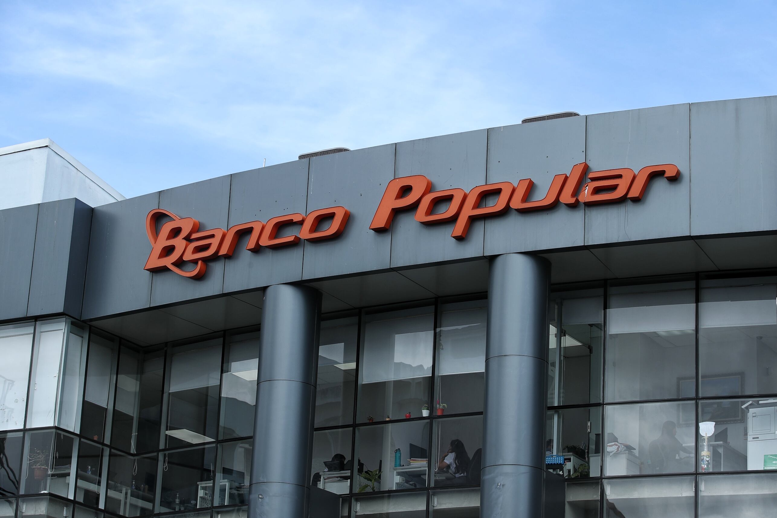 Edificio del Banco Popular en Costa Rica, con su logo visible. El banco ha aumentado significativamente su cartera de créditos para vehículos entre 2020 y 2024.